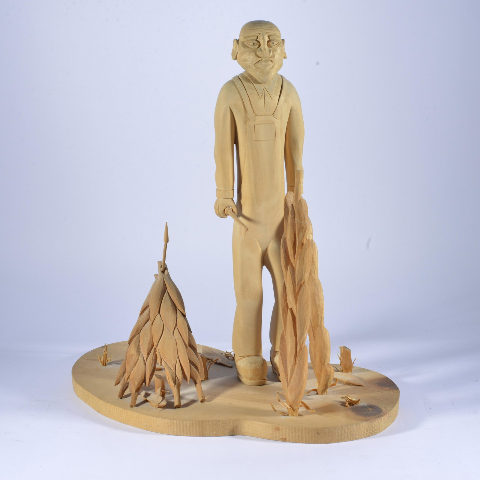JC Rose Folk art Carving: wood carved man cutting tobacco signed and dated on bottom 2003. height 18", width of base 20"
