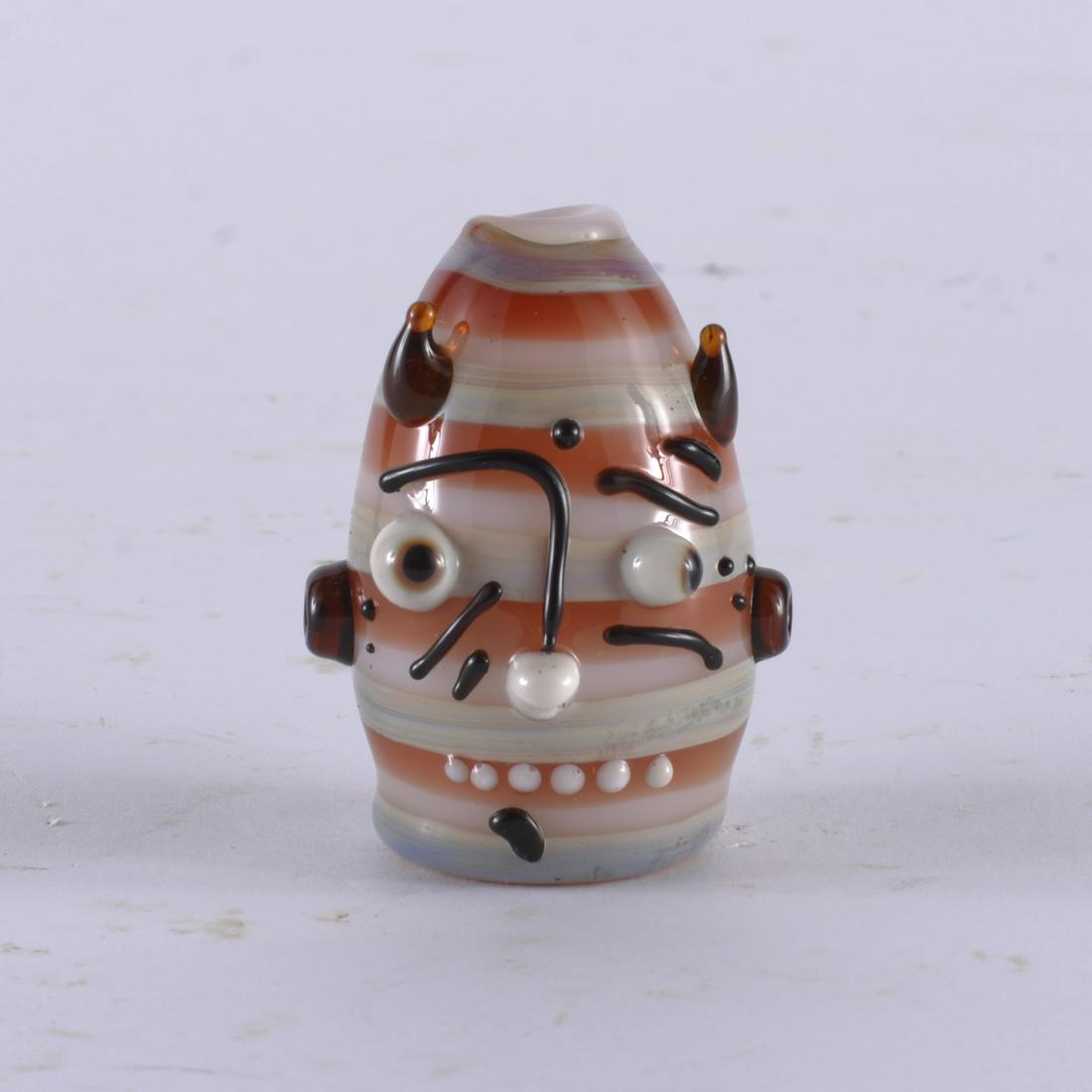 JOHNNY HAWKINS BLOWN GLASS MINIATURE FACE JUG: blown glass. A wonderful creation by 29 year old North Carolina artist Johnny Hawkins. Inspired by all the miniature pottery face jugs we handled over the last year in the gallery. Height 2"