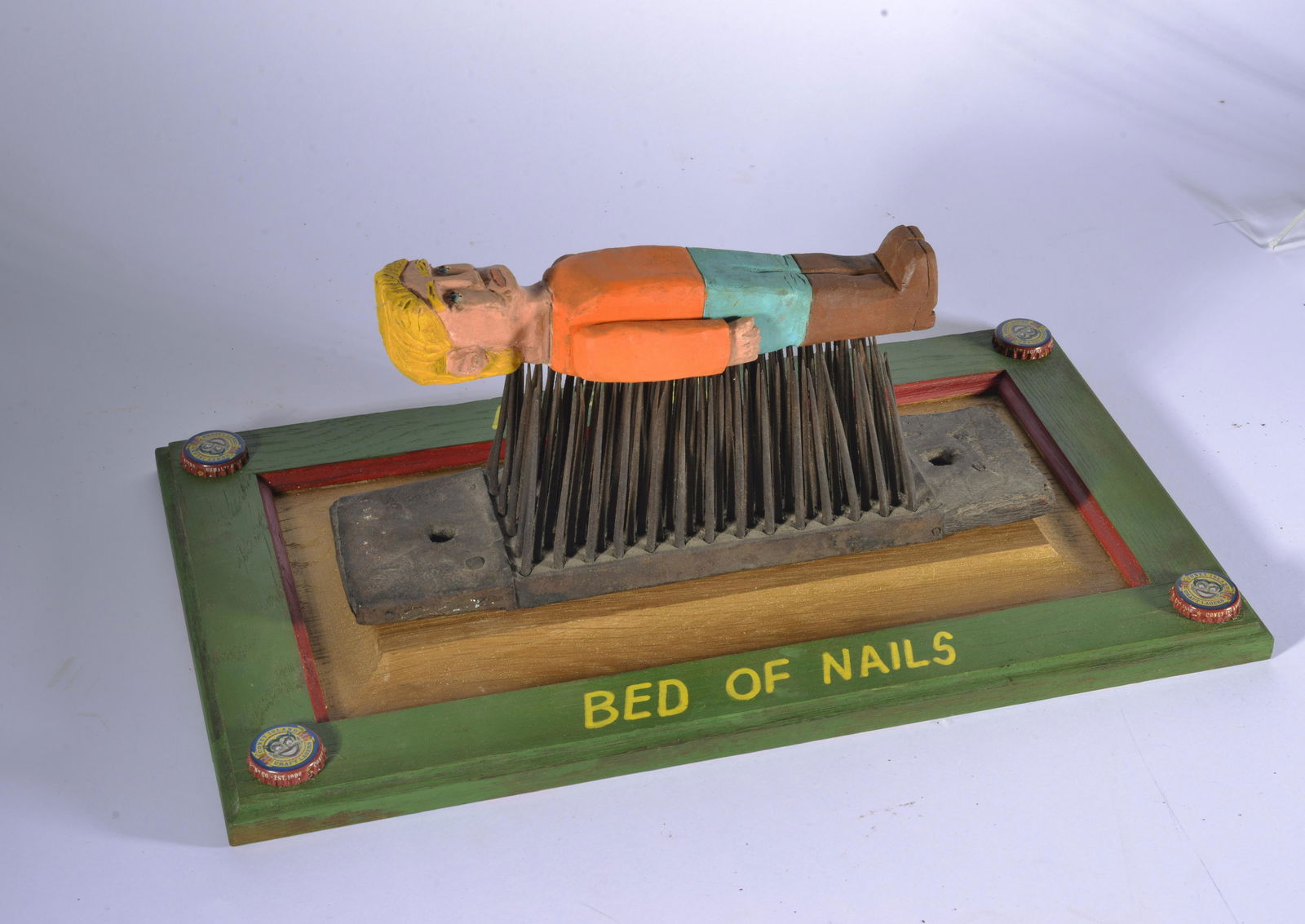 TOM "THE DEACON MAN" STECK FOLK ART: Bed of nails. Bed made with antique hatchel. carved man and paint on old wool tool. Artist built frame. Signed on back. 17"x10" 8" tall