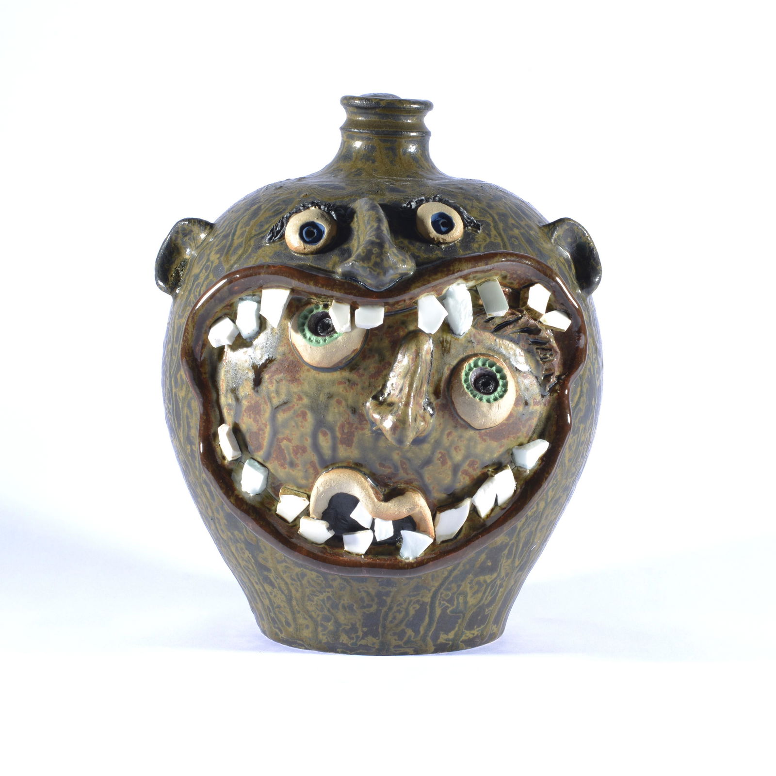 RODNEY LEFTWICH FACE WITHIN A MOUTH FACE JUG NC POTTERY: During the 1970s, Rodney Leftwich followed the regional folk pottery traditions of western North Carolina. Inspired, he purchased a potters wheel and learned to make pottery. His first pieces included