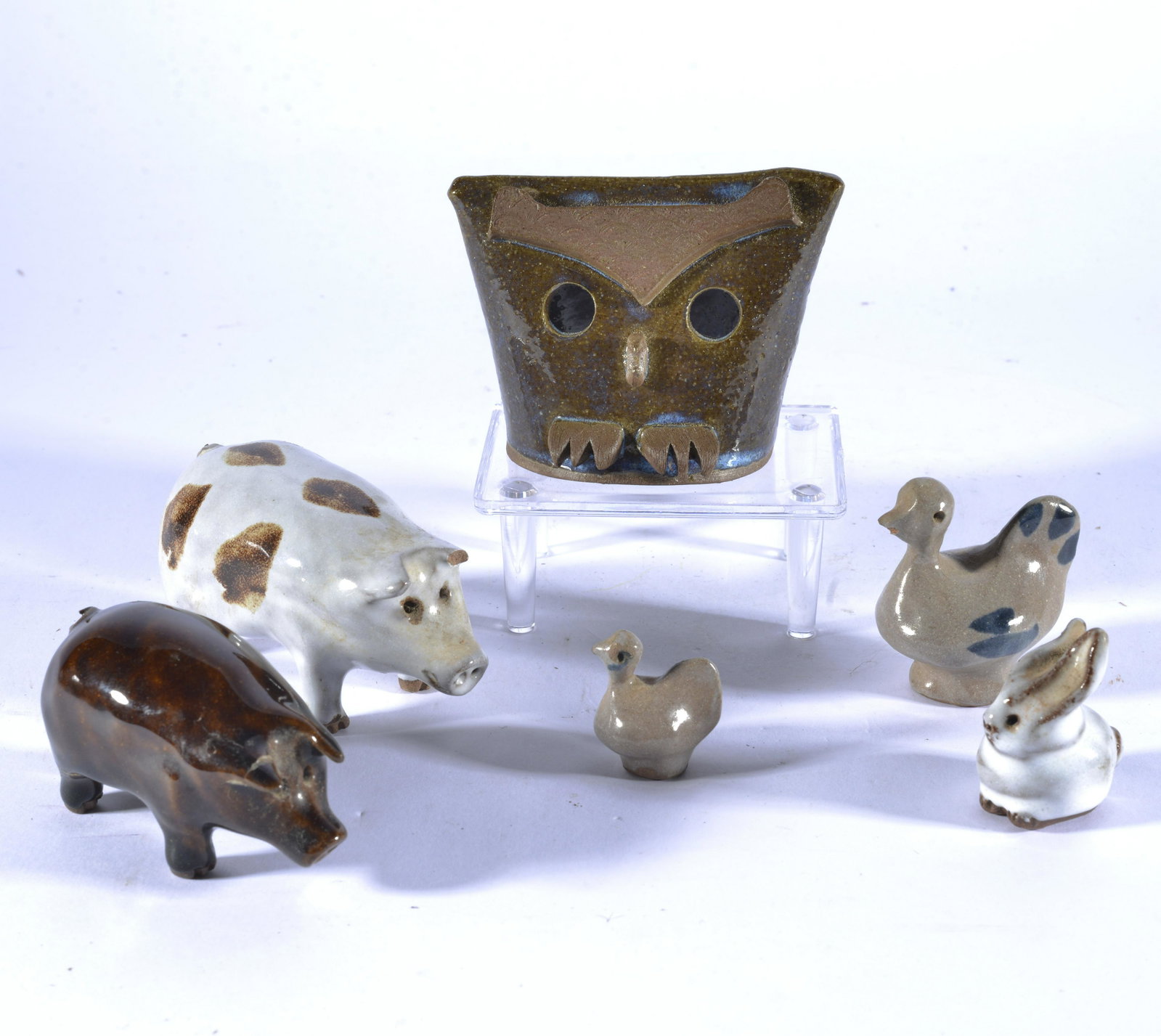 FOLK ART POTTERY GROUPING OF PIGS & OWL FACE POT: The owl is the only noted signed pot, marked Karen Wright. Largest pig is 3.75" long. Same pig has a chip to the ear & reglued leg.