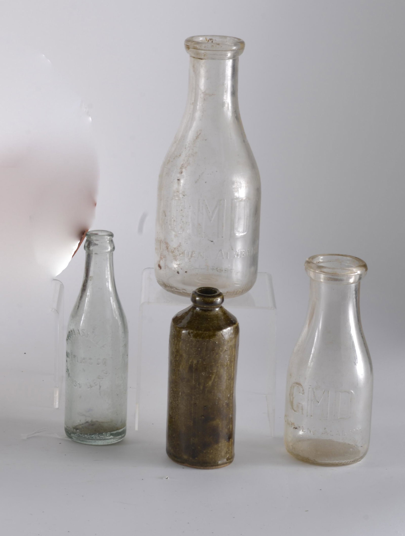 Milk Bottle Group: 4 bottles total. one bottle is pottery. good condition