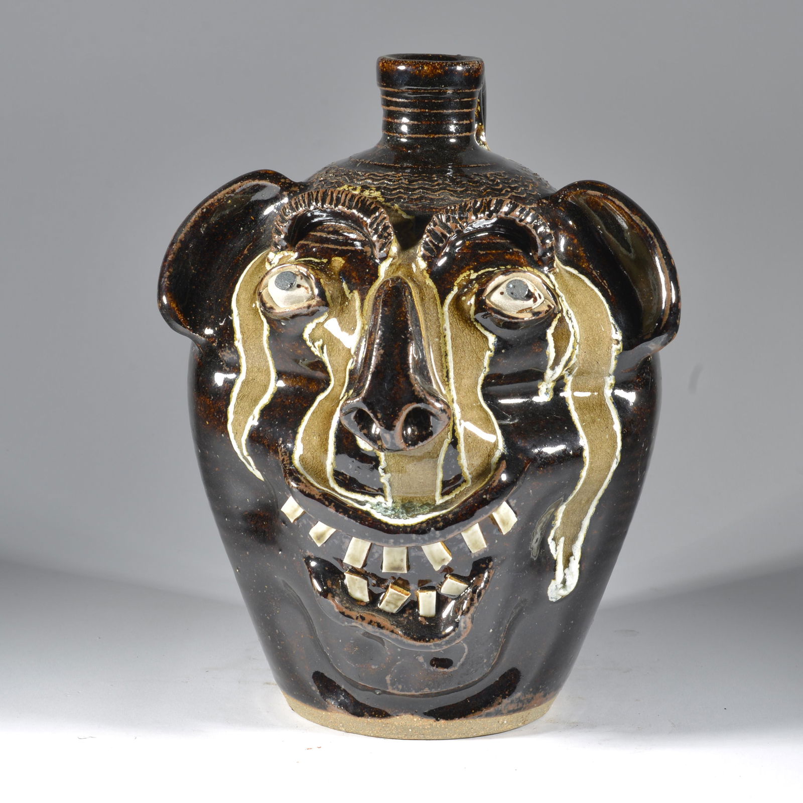 Charles Charlie Lisk Face Jug Glass Runs Face Jug Catawba Valley NC Pottery: A distinctly Charlie Lisk form in the creation of the face; very similar to Lot #53, but a bit smaller and slightly later (this face is circa 2000). He has tremendous fun with the facial expressionism