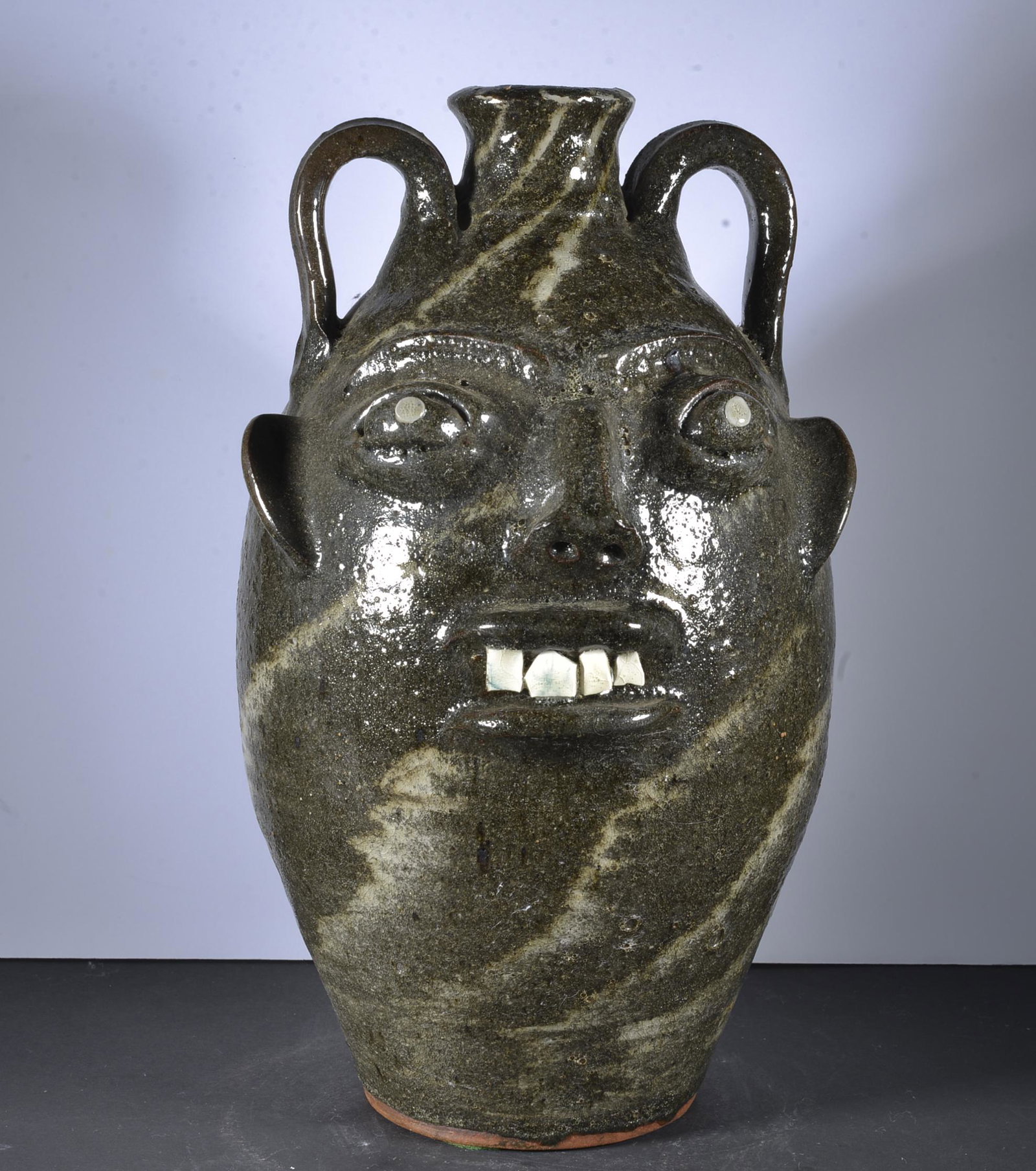 WALTER FLEMING FACE JUG: A FANASTIC DRAMATIC GLAZE, SIGNED WITH VERY SMALL STAMP AT THE BASE CHINA TEETH AND SWIRL GLAZE 12.5" TALL