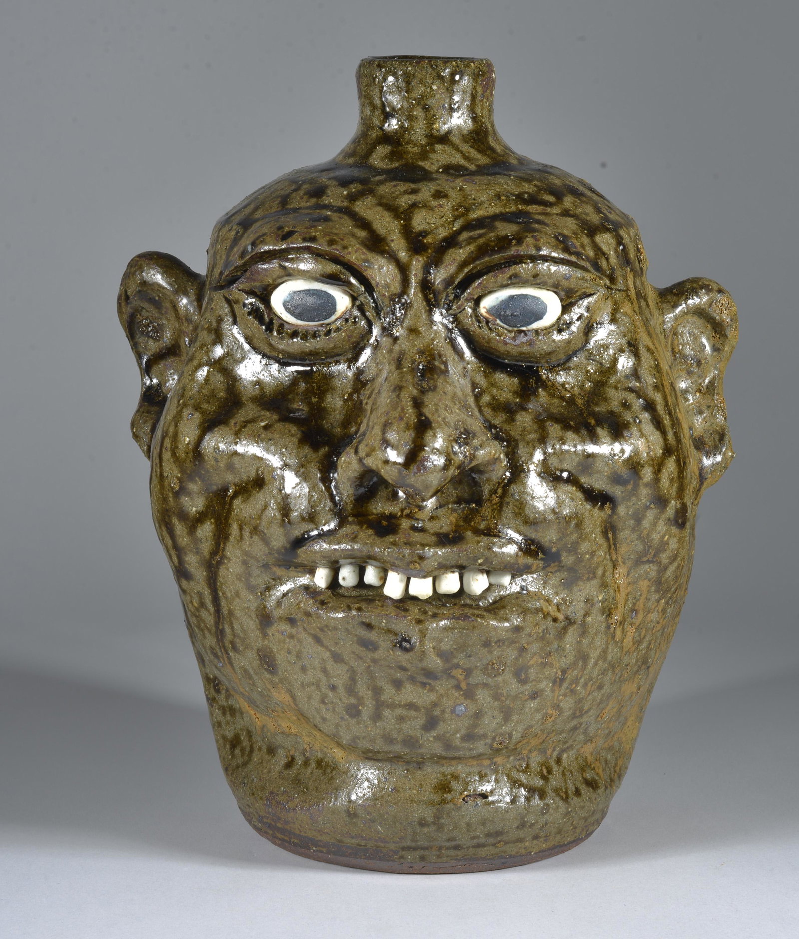 Lanier Meaders Face Jug: 9.5" Clay eyes, clay teeth. Alkiline glaze. Mint as fired condition. Signed on bottom.