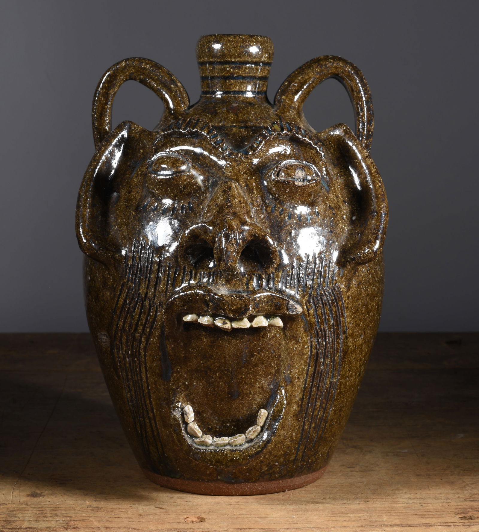 Steve Abee Face Jug: double handle, alkaline glaze, clay teeth. Signed on bottom. 10.5"H