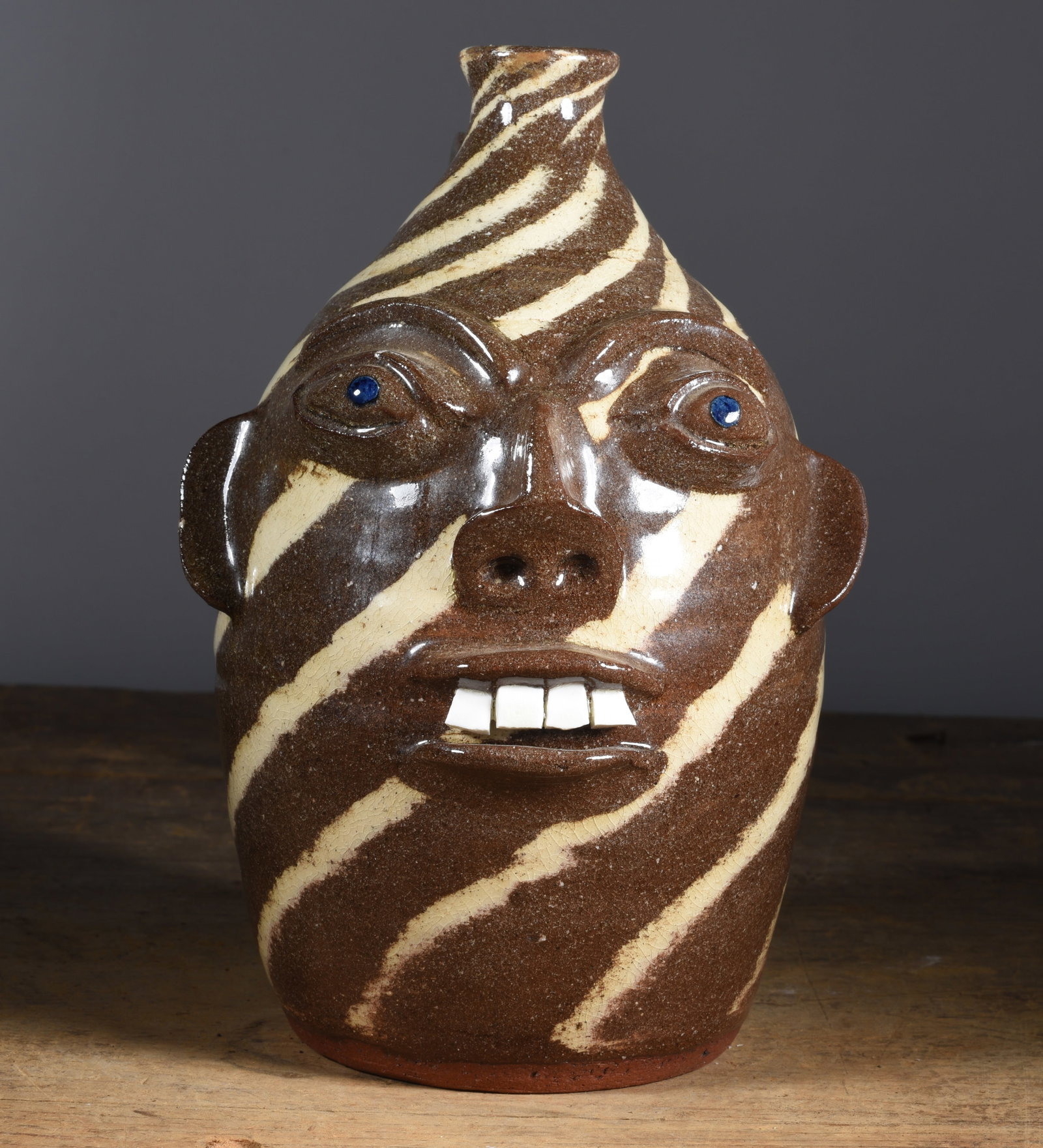 Walter Flemming Swirl Face Jug: signed on bottom, blue eyes. Single row of broken china teeth. 9.5"H