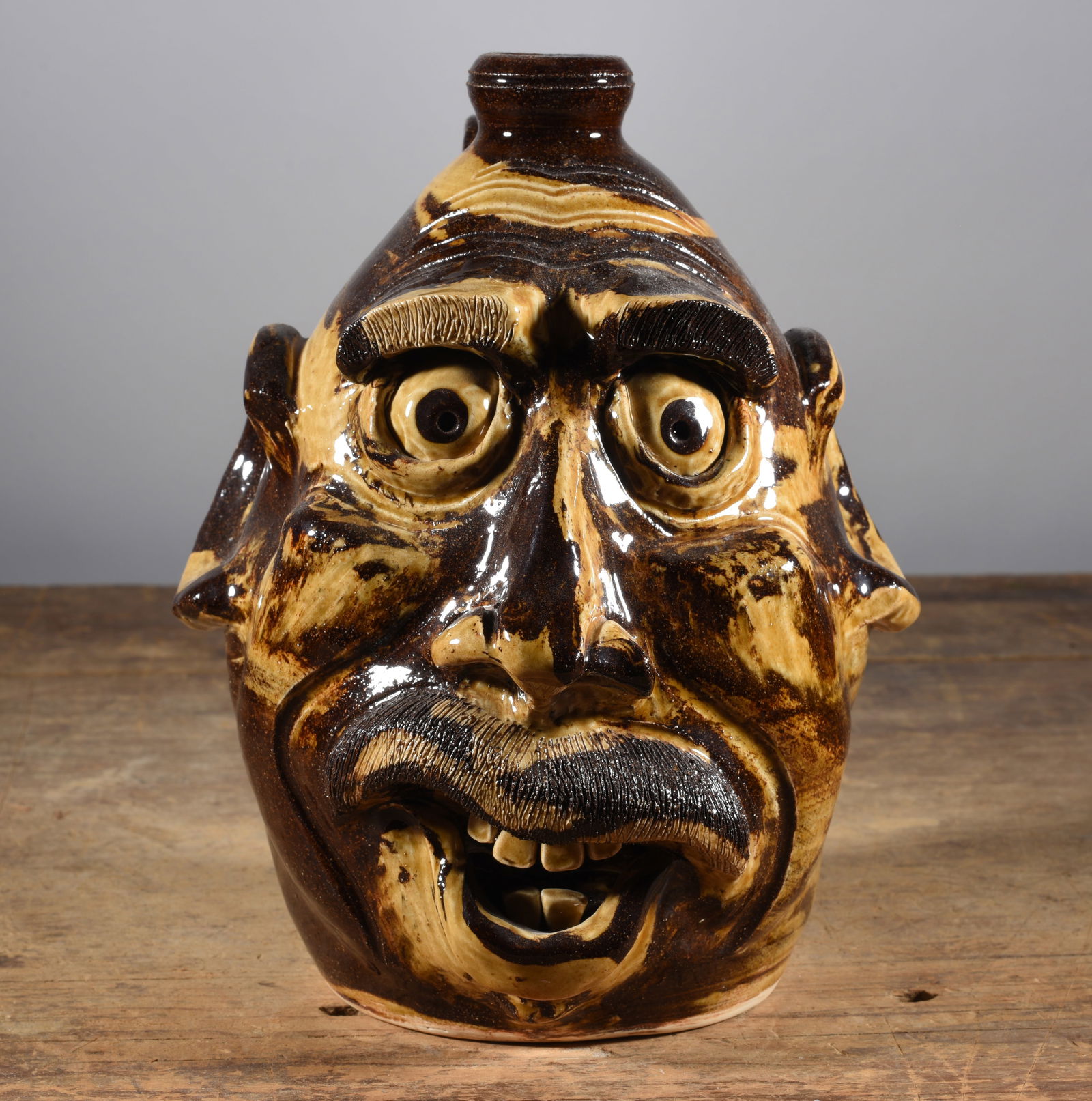 Dwayne Crocker Face Jug: 10" wonderful multi glaze, with mastache. Clay teeth and clay eyes. Signed on bottom.