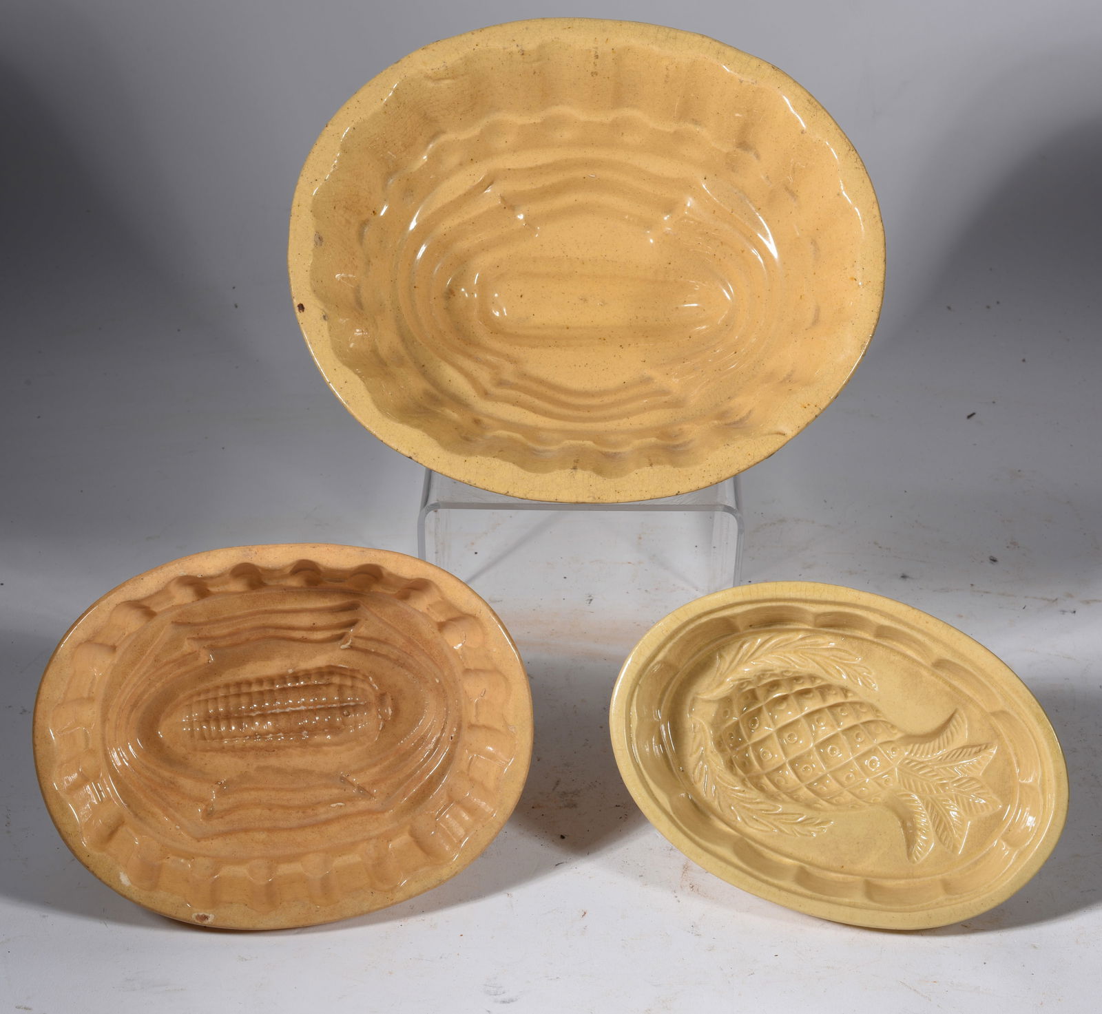 Yellow ware cake molds: Largest is 9" x 4" from a collection of yellow ware, see photos for damage.