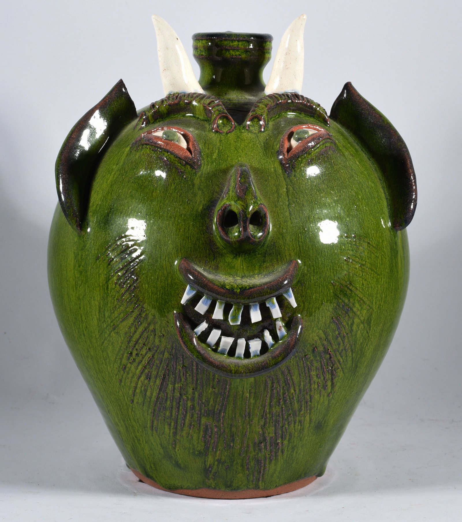 AV Smith Face Jug: 9" very nice green glaze, double row of china plate teeth. Signed.