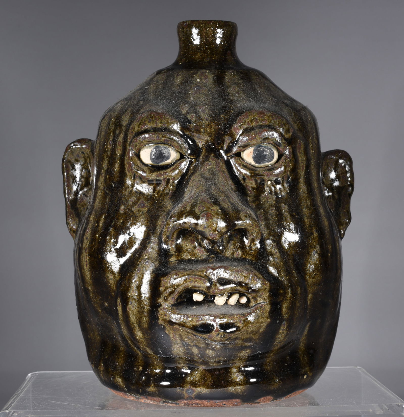 Lanier Meaders Face Jug: 9.5" alkaline glaze face jug by Lanier Meaders with African American features. Clay eyes and clay teeth. Signed on bottom.