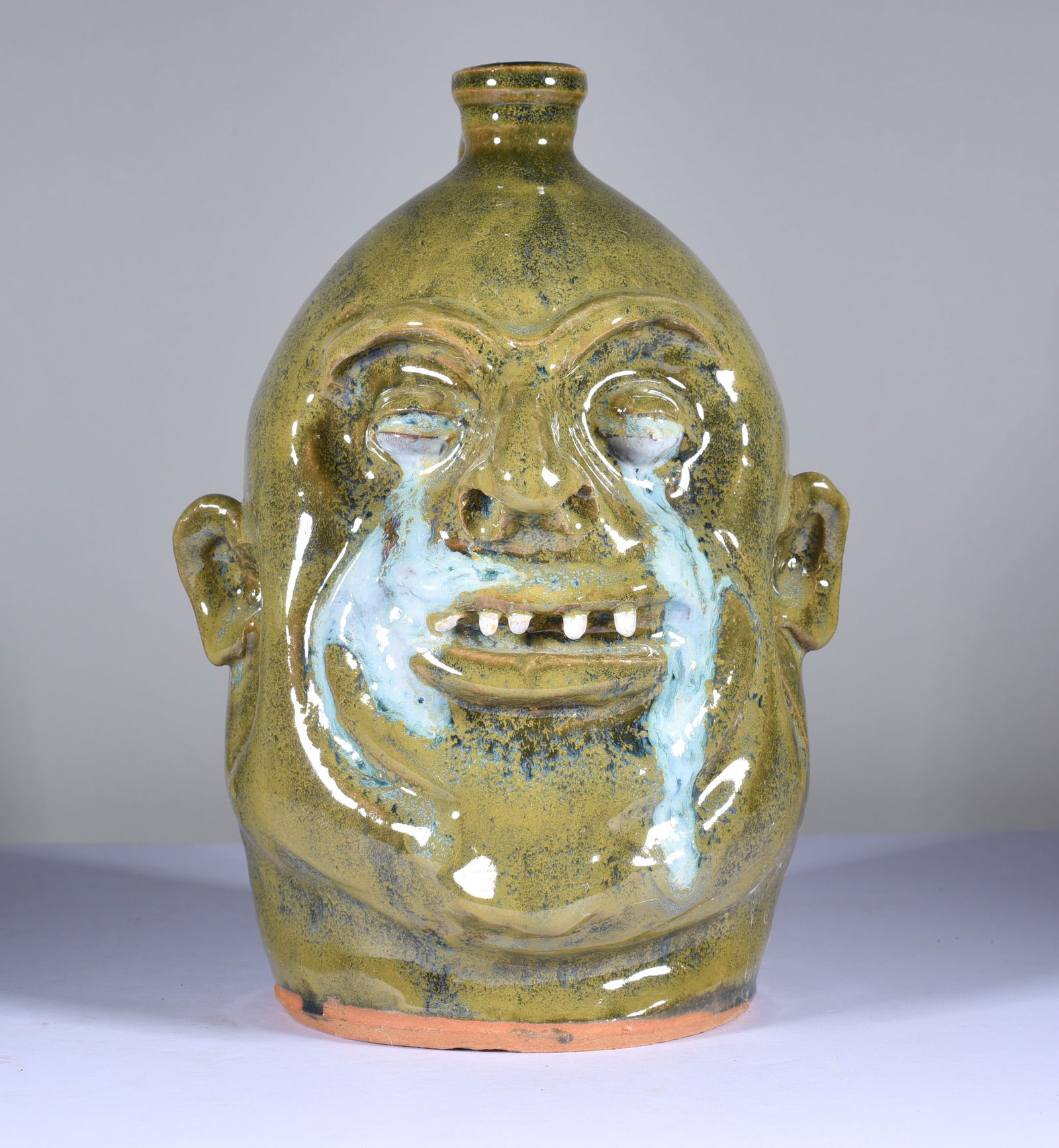 Marvin Bailey Crying Eye Face Jug: 9" very nice folk pottery face jug with the crying eyes, melted glass eyes. Signed on bottom, fired in a very beautiful green glaze. Clay teeth. Mint condition.