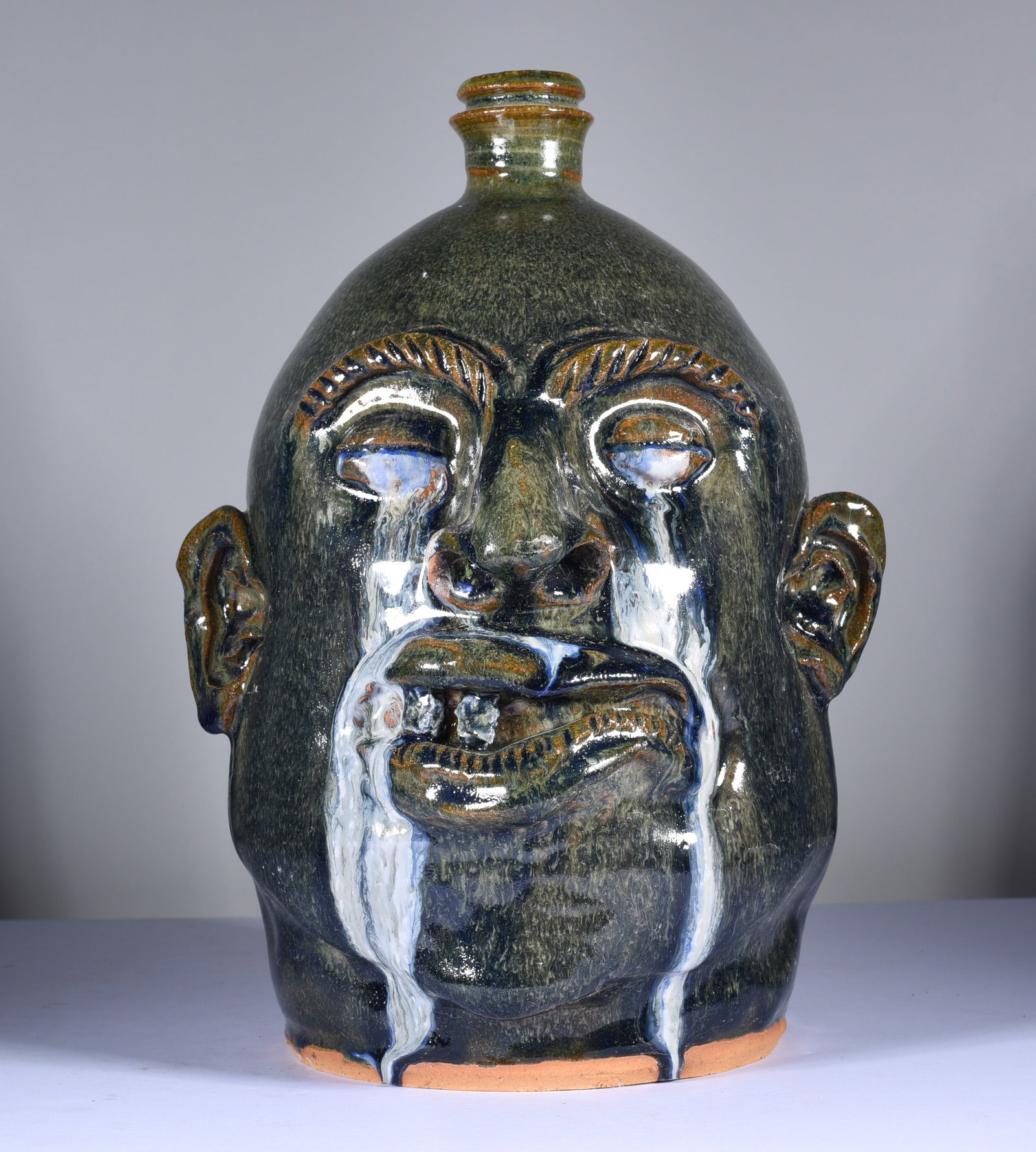 Marvin Bailey Crying Eye Face Jug: 11" just an awesome face jug by Marvin Bailey! Incredible crying eyes with a turned up curled lip showing only two rock teeth. An outstanding example of folk pottery by Marvin Bailey. Mint condition.
