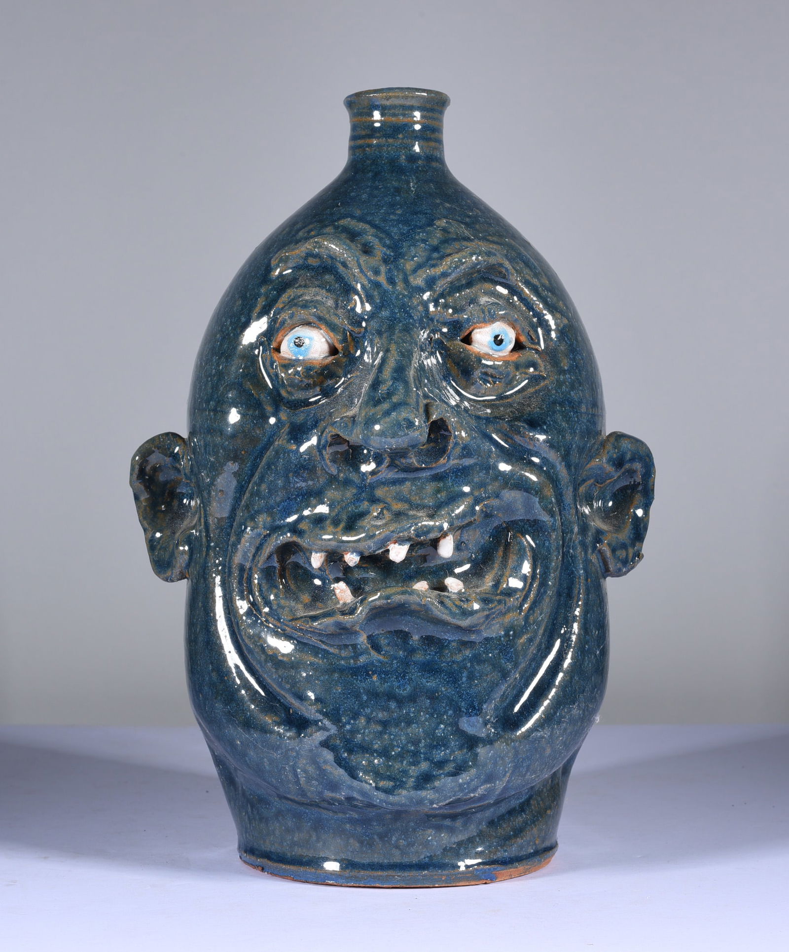 Marvin Bailey Face Jug: 9" interesting blue green glaze with an open mouth and two rows of clay teeth. Signed on bottom. Mint condition.