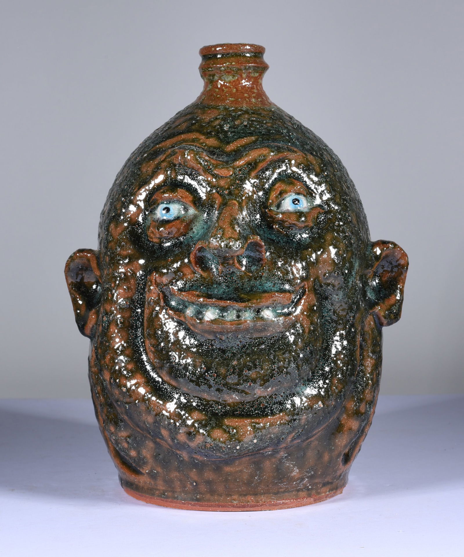 Marvin Bailey Face Jug: 8.5" very interesting glaze with an enhanced firing that brought out very interesting details in the clay. Single row of teeth that have heavy glaze over them. Signed on bottom. Mint condition.