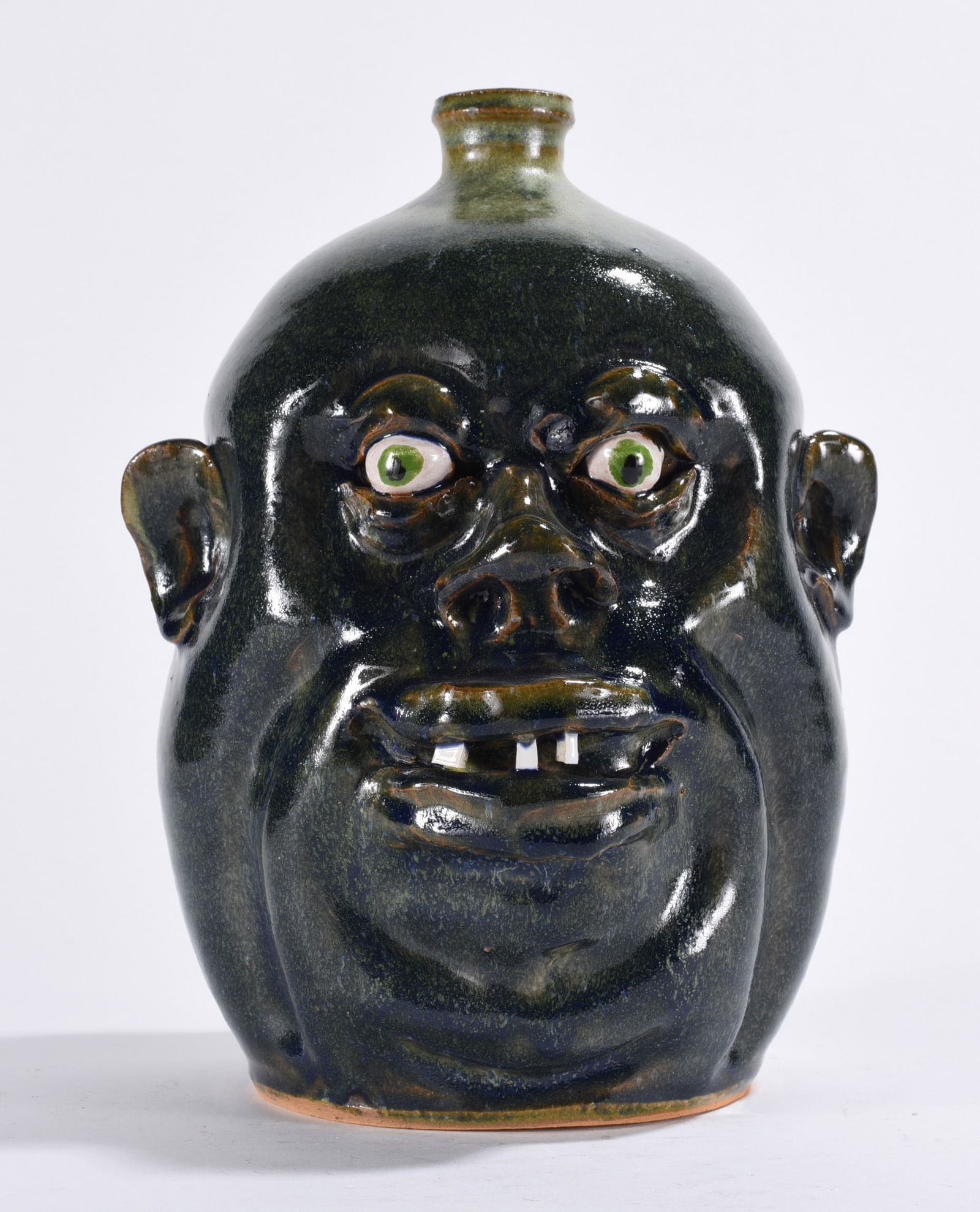 Marvin Bailey Face Jug: a dark glazed face jug with china plate teeth and clay eyes. Signed on bottom.