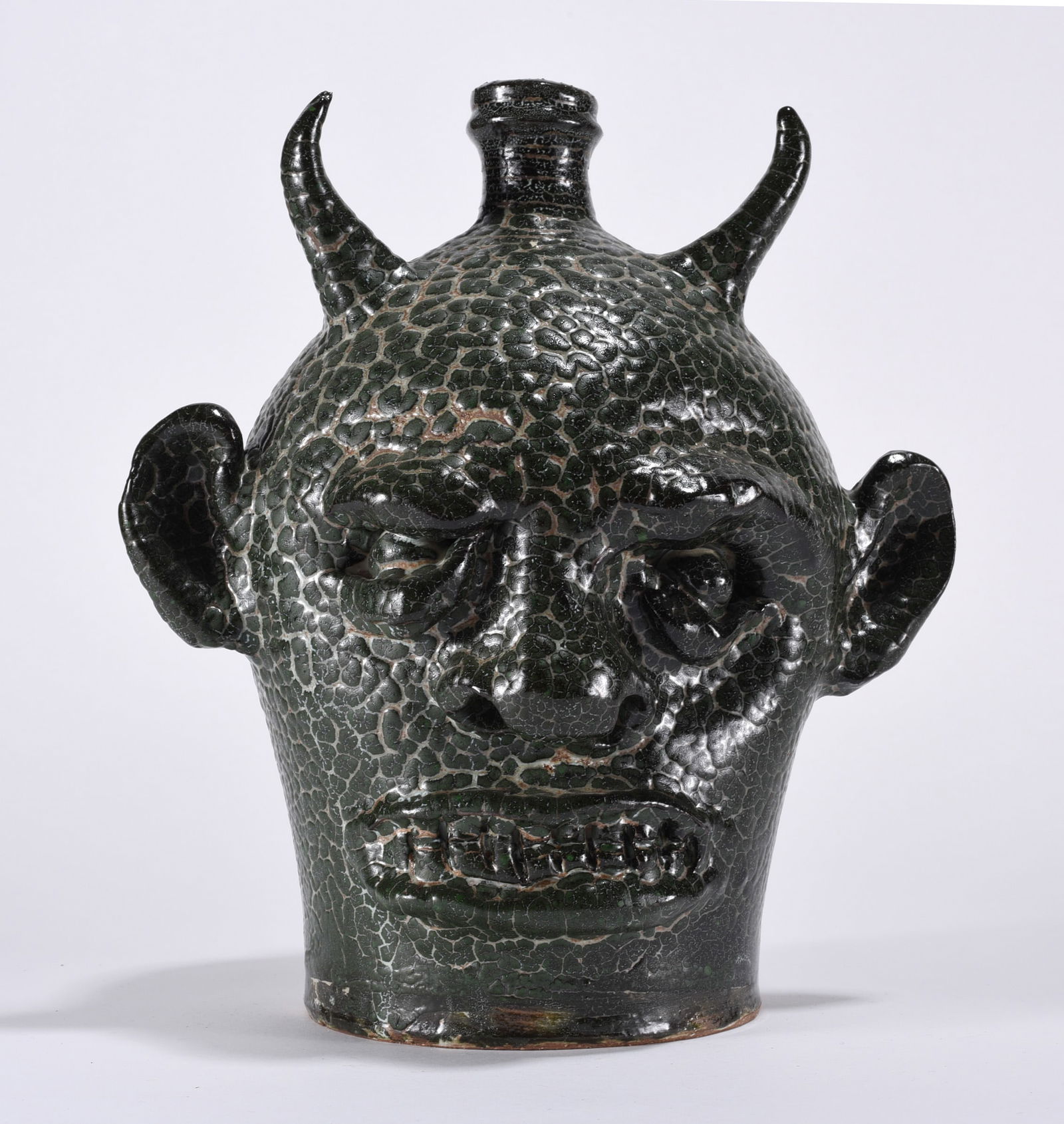 Marvin Bailey Devil Face Jug: 10" early face jug by Marvin Bailey. Clay eyes and clay teeth. Outstanding texture in the glaze. All items can be in house shipped to get in house shipping select SELF ARRANGE. Shipping takes 3 weeks