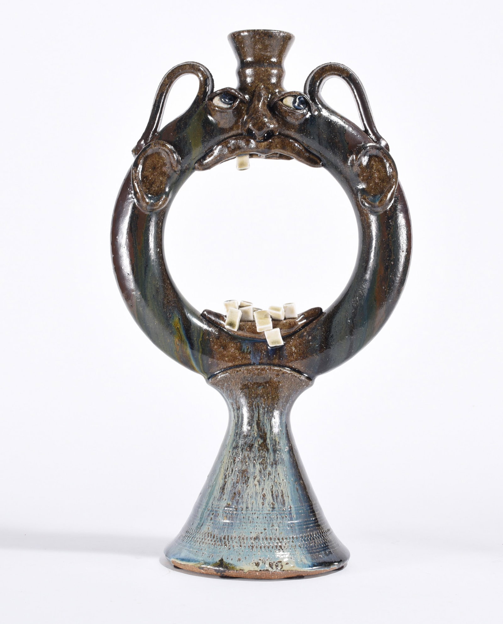 Folk Pottery Ring Jug with Face: 16.5" - folk pottery ring jug with face. China plate teeth. Intetesting piece of folk pottery with an alkaline glaze and blue runs on the bottom. Signed on bottom.