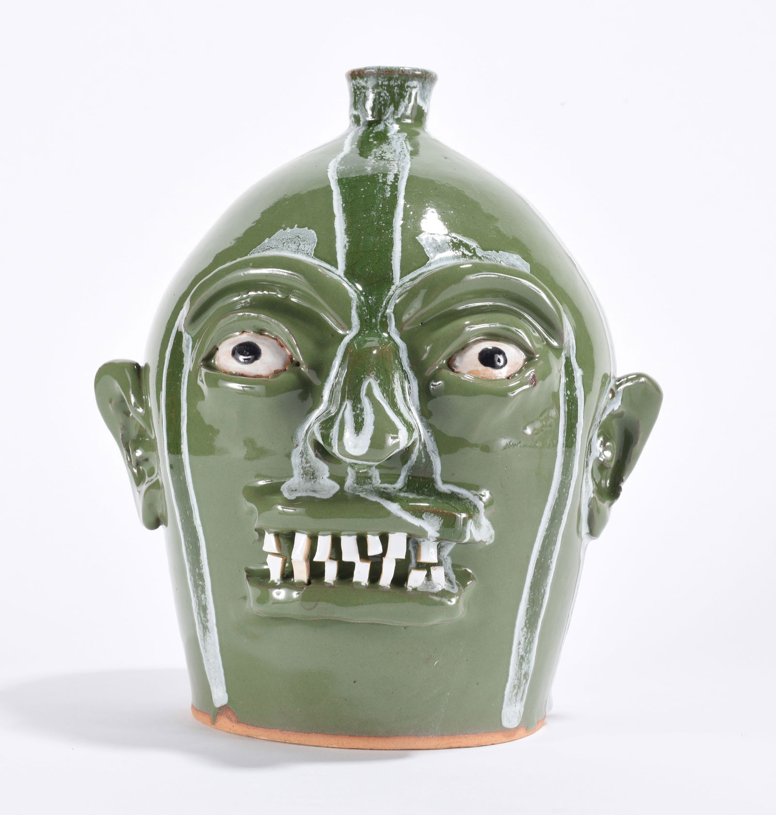 Marvin Bailey Face Jug: 10" - face jug by Marvin Bailey with two rows of broken china teeth. A green glaze with darker green runs. Clay eyes. Signed on bottom.