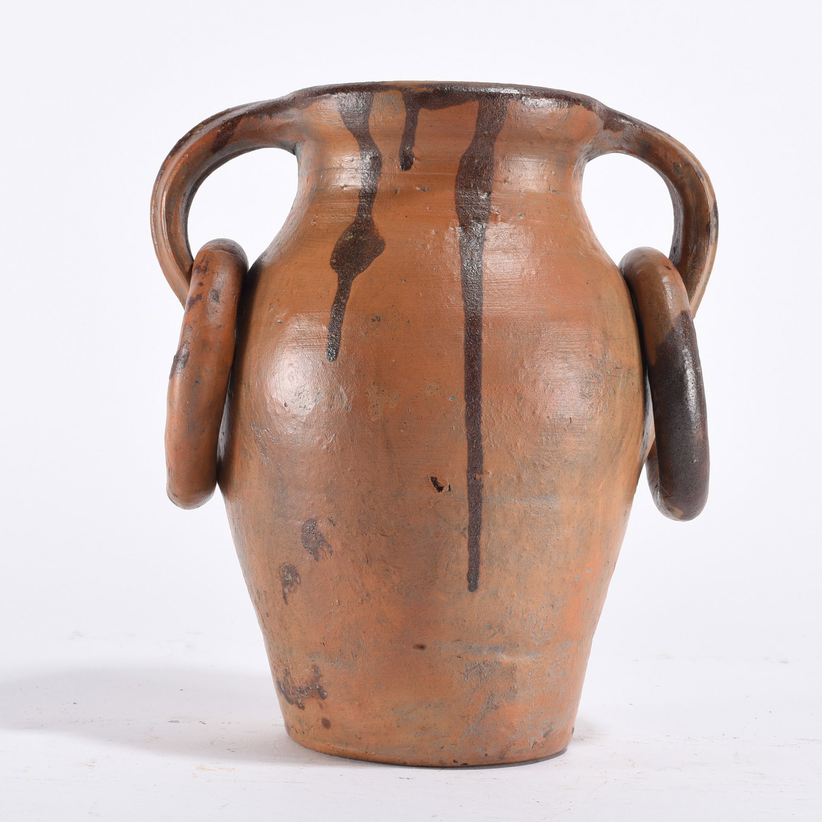Southern Earthenware Storage Jar with Lug Handles: Late 19th to early 20th century. Hand-thrown utilitarian jar with applied lug handles and dark alkaline glaze drips at the shoulder. Traditional Southern pottery form used for storage. Surface wear co
