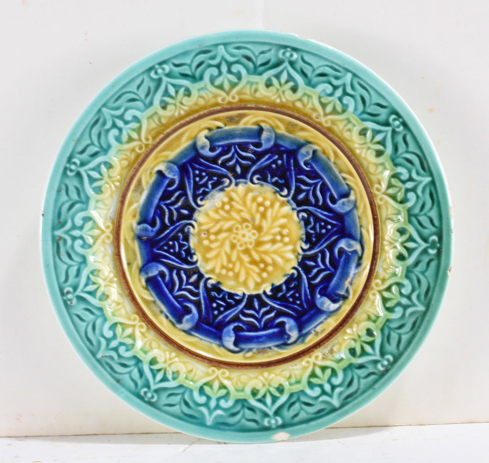 Majolica Style Decorative Plate: Colorful majolica style plate with raised floral and scroll decoration in blue, green, and yellow. We do offer in house shipping for items under 36" - boxes 10"x10"x10" we can ship for around $21 or l