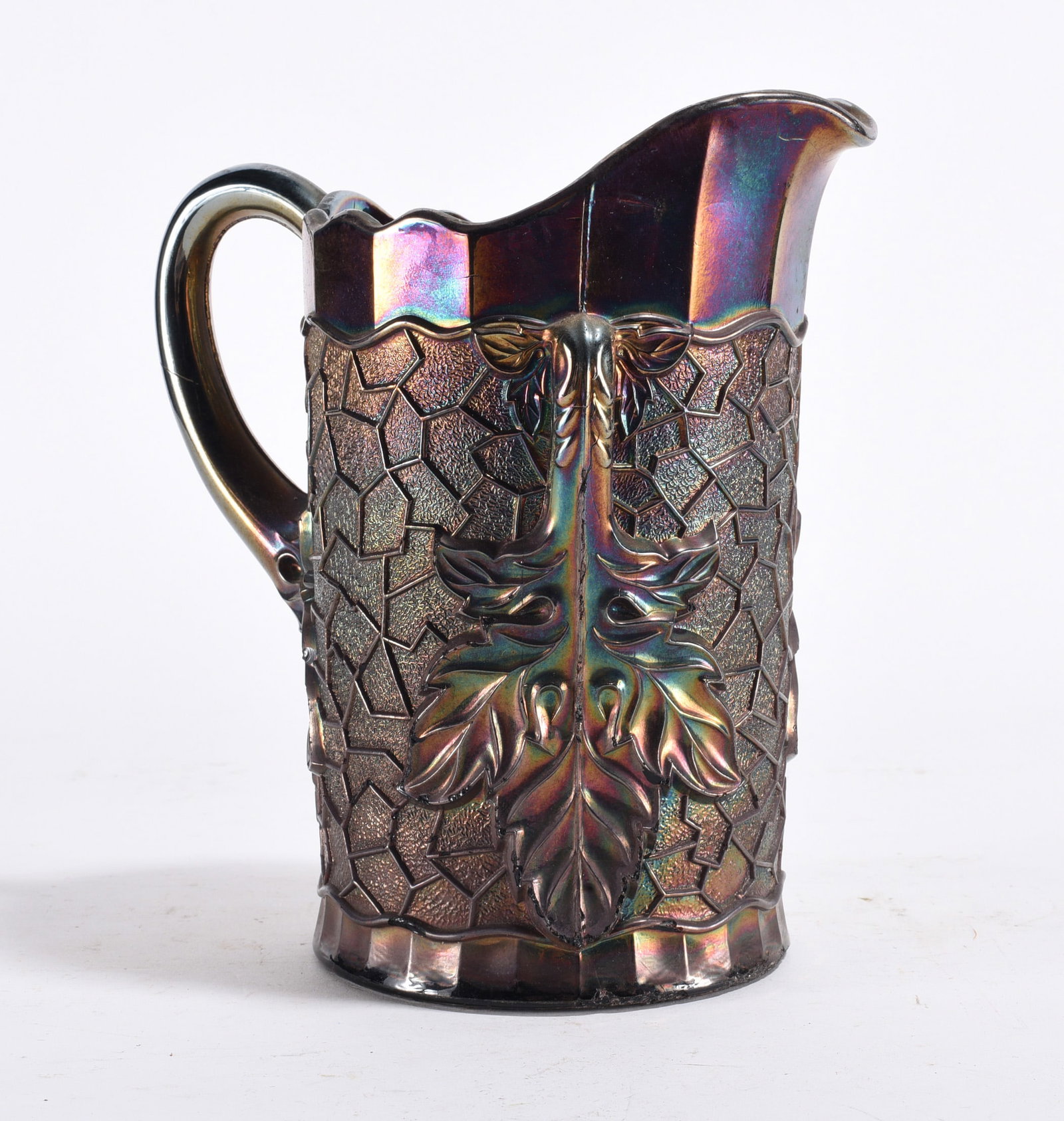 Carnival Glass Pitcher: Iridescent carnival glass pitcher with raised leaf and geometric design