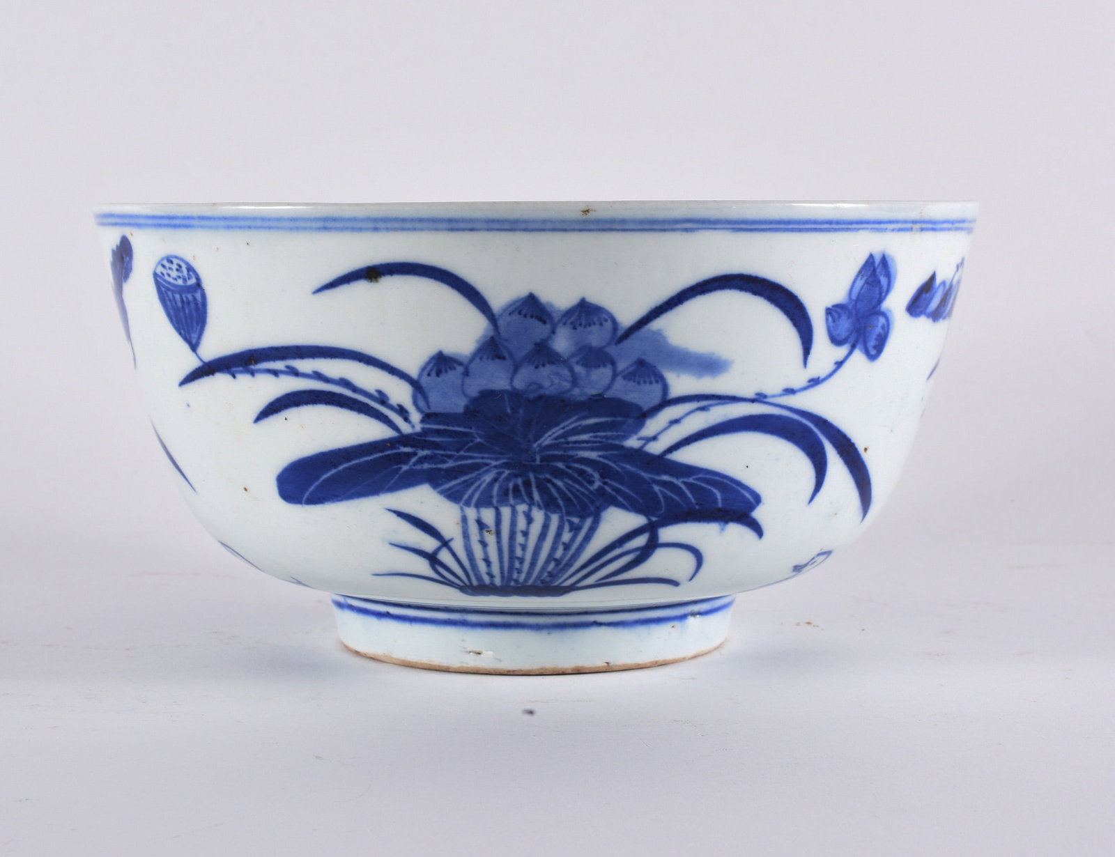 Chinese Blue and White Porcelain Bowl with Lotus Motif: 9" diameter, 4" tall Porcelain bowl decorated in underglaze cobalt blue featuring a central lotus blossom with scrolling vines and floral elements. Raised on a short foot with double blue line border.