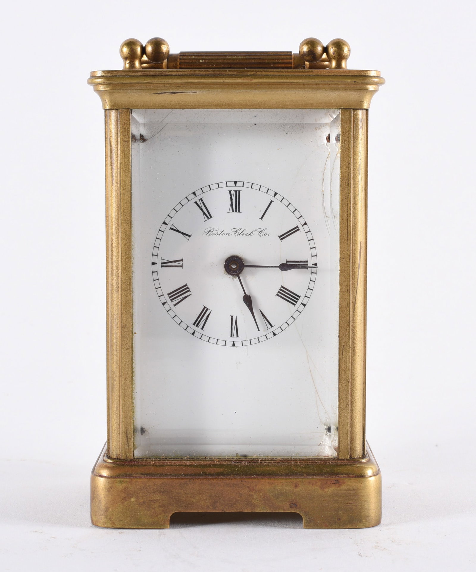 Boston Clock Co. Brass Carriage Clock: 5" Brass carriage clock with glass paneled case and white enamel dial signed “Boston Clock Co.” Roman numeral hour markers and visible mechanical movement. Likely early 20th century example.