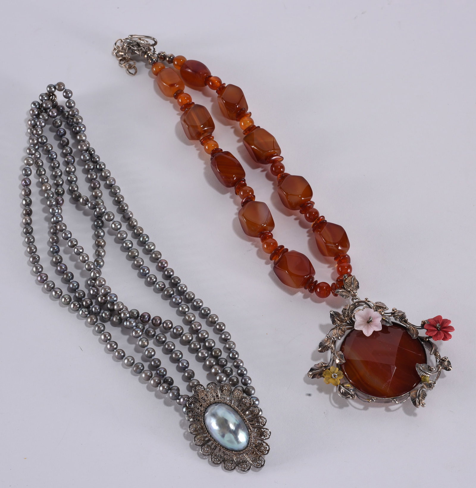 Huge agate necklace with floral silver details. Three small flowers on pendant. 16"?plus; Hand: Huge agate necklace with floral silver details. Three small flowers on pendant. 16"?plus; Hand knotted grey pearl necklace with grey nautilus shell pendant. Sterling Silver clasp. 18"