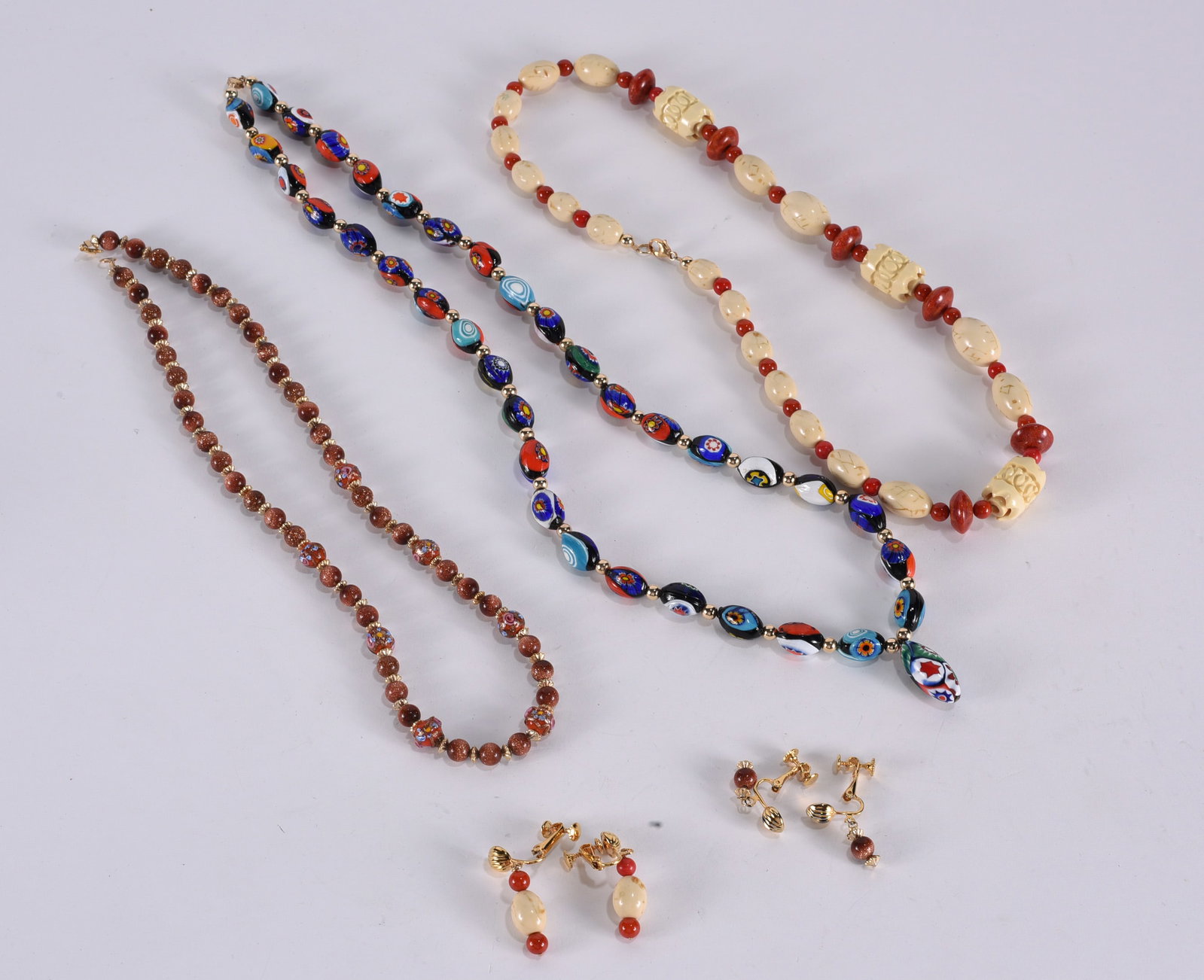 Sunstone bead necklace with Murano wedding cake bead accents. Gold tone with matching earrings.: Sunstone bead necklace with Murano wedding cake bead accents. Gold tone with matching earrings. 20"?plus; Unusual beaded necklace with coral and agate accents. Oval white beads have etched designs. Go