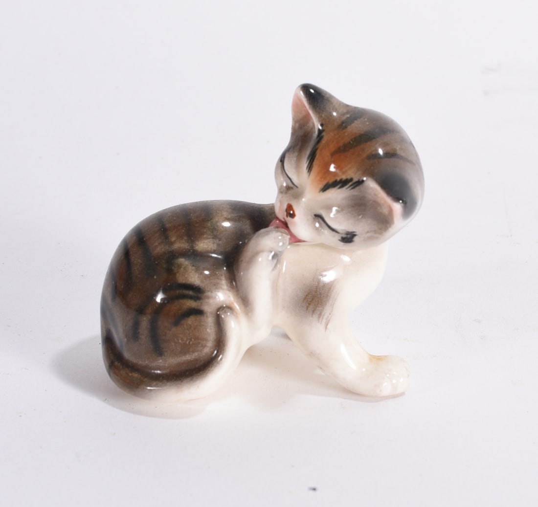 Grooming Kitten Ceramic Figure: Vintage ceramic kitten figurine modeled grooming itself, featuring hand-painted striped decoration and glossy finish.
