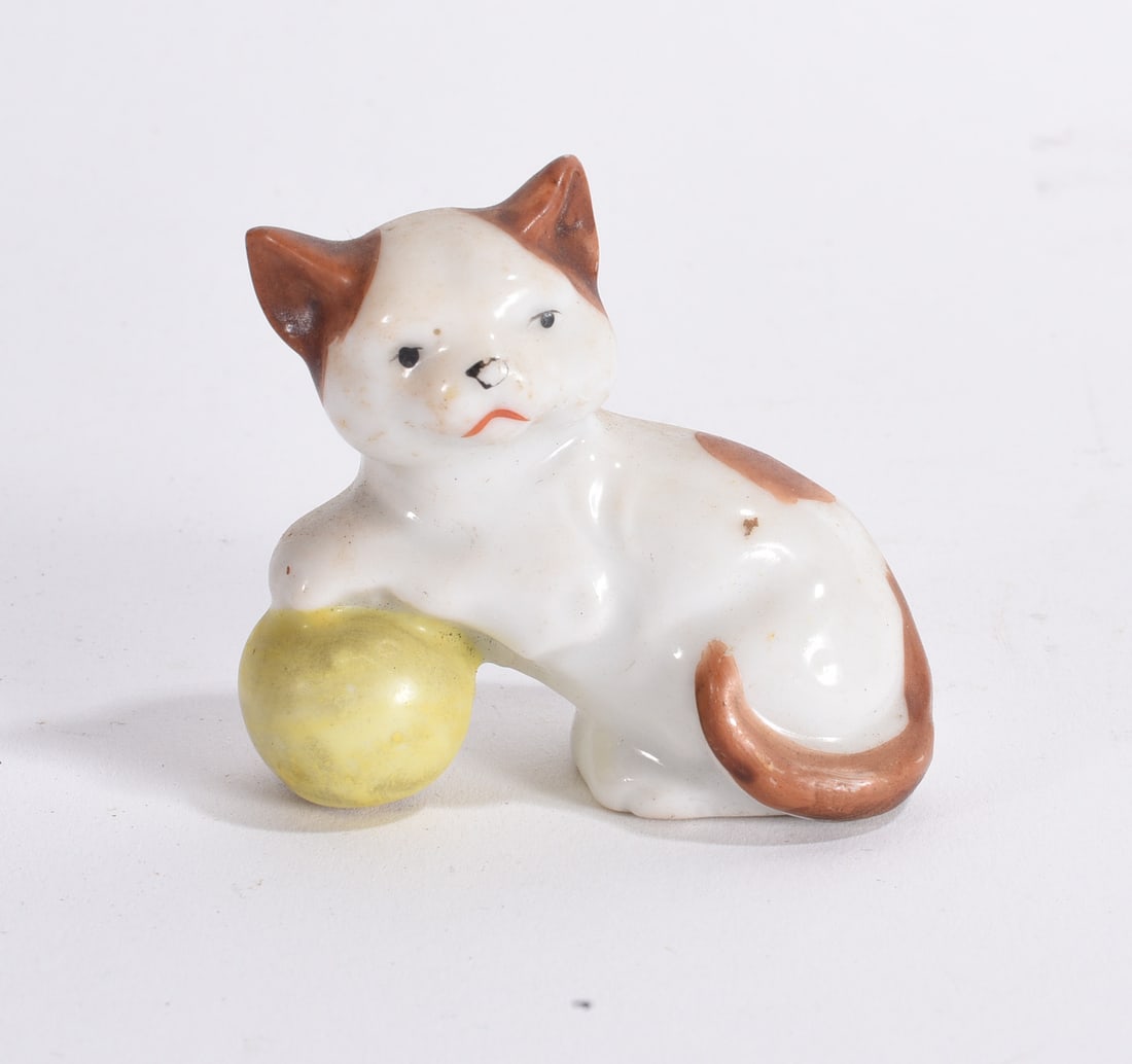 Ceramic Cat with Ball Figurine: Vintage white and orange ceramic cat figurine resting beside a yellow ball, with hand-painted facial features.