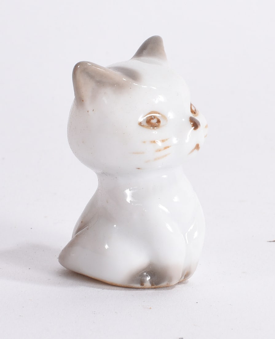 White Ceramic Kitten Figurine: Small white glazed ceramic kitten figurine with hand-painted whiskers and facial decoration.