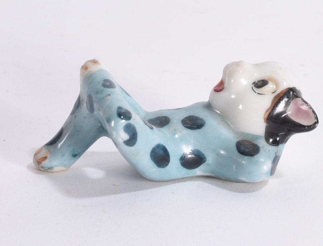Blue Polka Dot Cat Figurine: Whimsical ceramic cat figurine with blue glaze and black spots, modeled reclining with elongated form.
