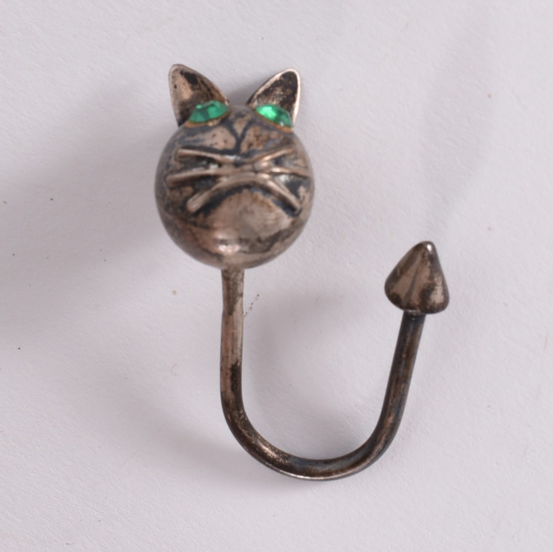 Sterling Silver Cat Ring: Sterling silver cat-form ring with green stone eyes and stylized whisker decoration.