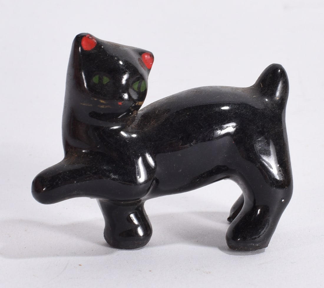 Miniature Black Cat Figurine: Small black glazed ceramic cat figurine with green eyes and raised paw pose.