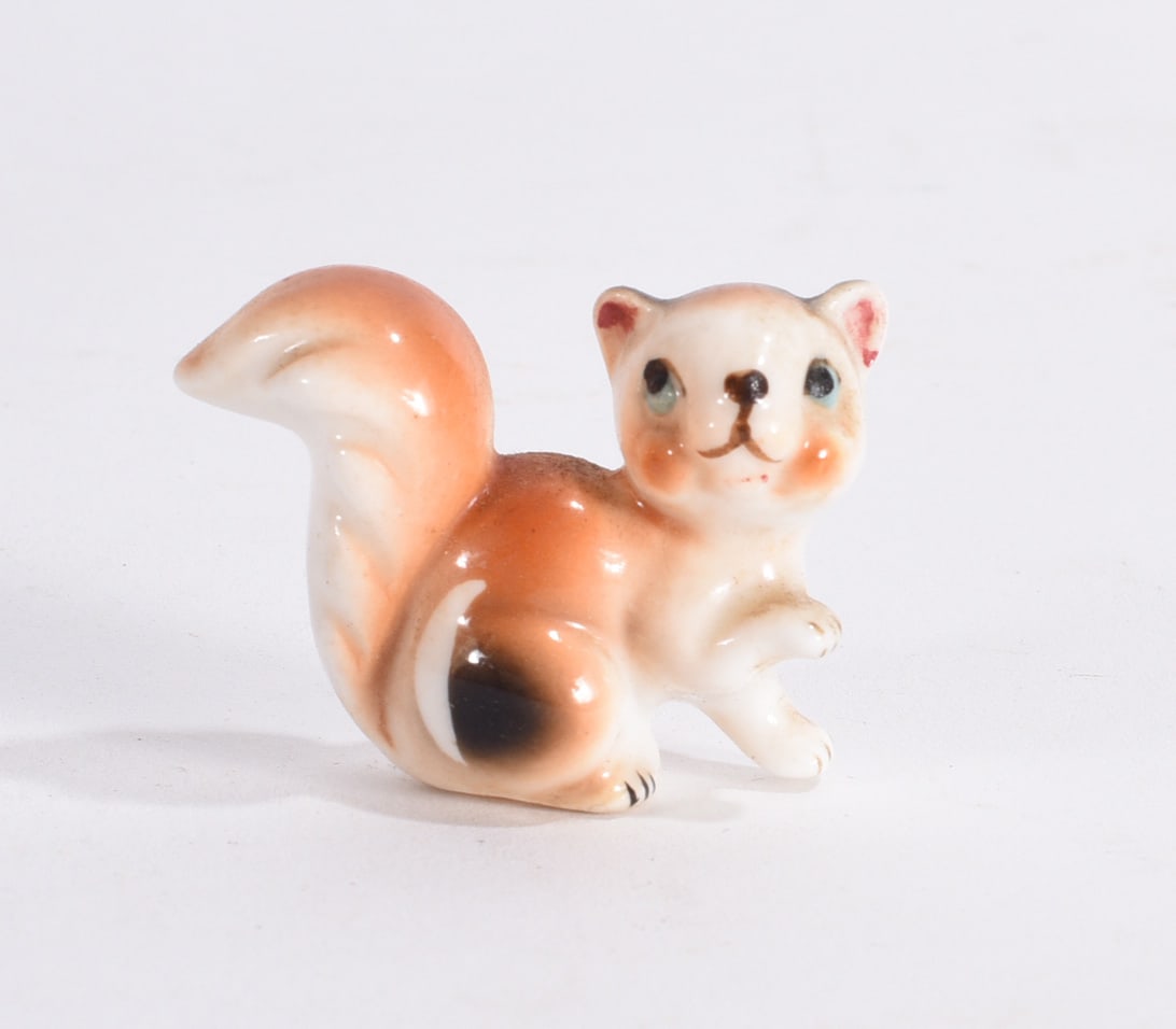 Miniature Squirrel Ceramic Figurine: Miniature ceramic squirrel figurine with orange glaze and raised tail, hand-painted facial decoration.