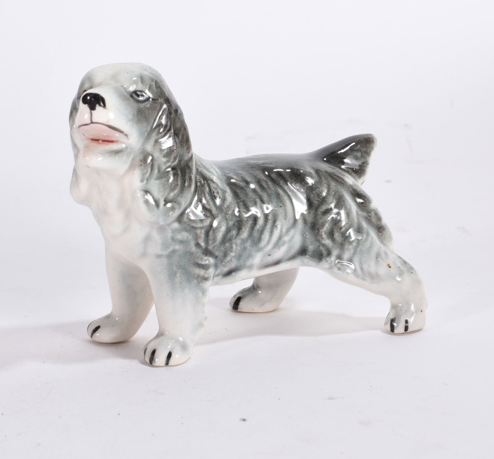 Spaniel Dog Figurine: Vintage ceramic spaniel dog figurine with gray and white glaze and textured fur detail.