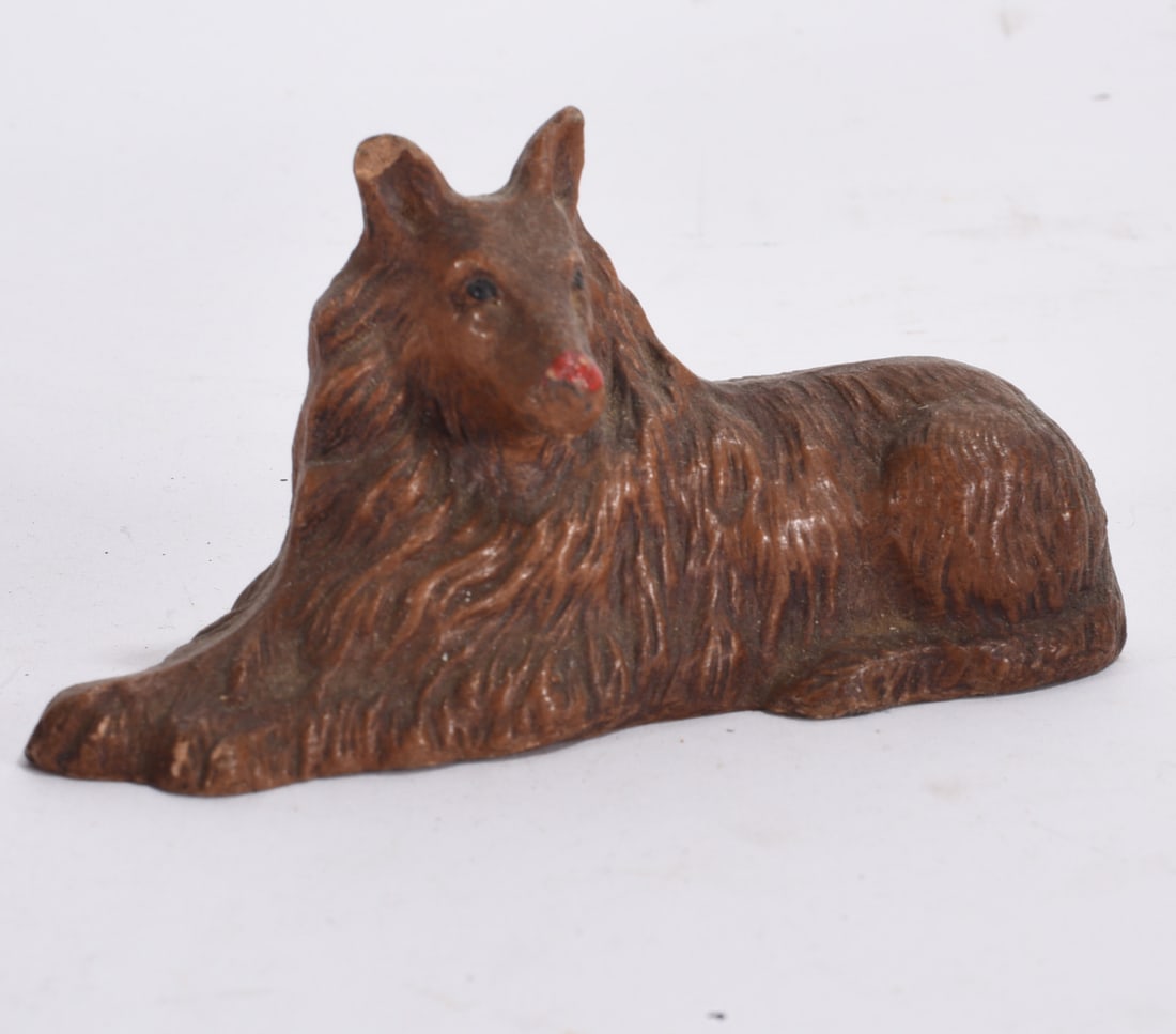 Miniature Brown Dog Figurine: Miniature brown dog figurine in reclining pose with textured coat and painted facial detail.