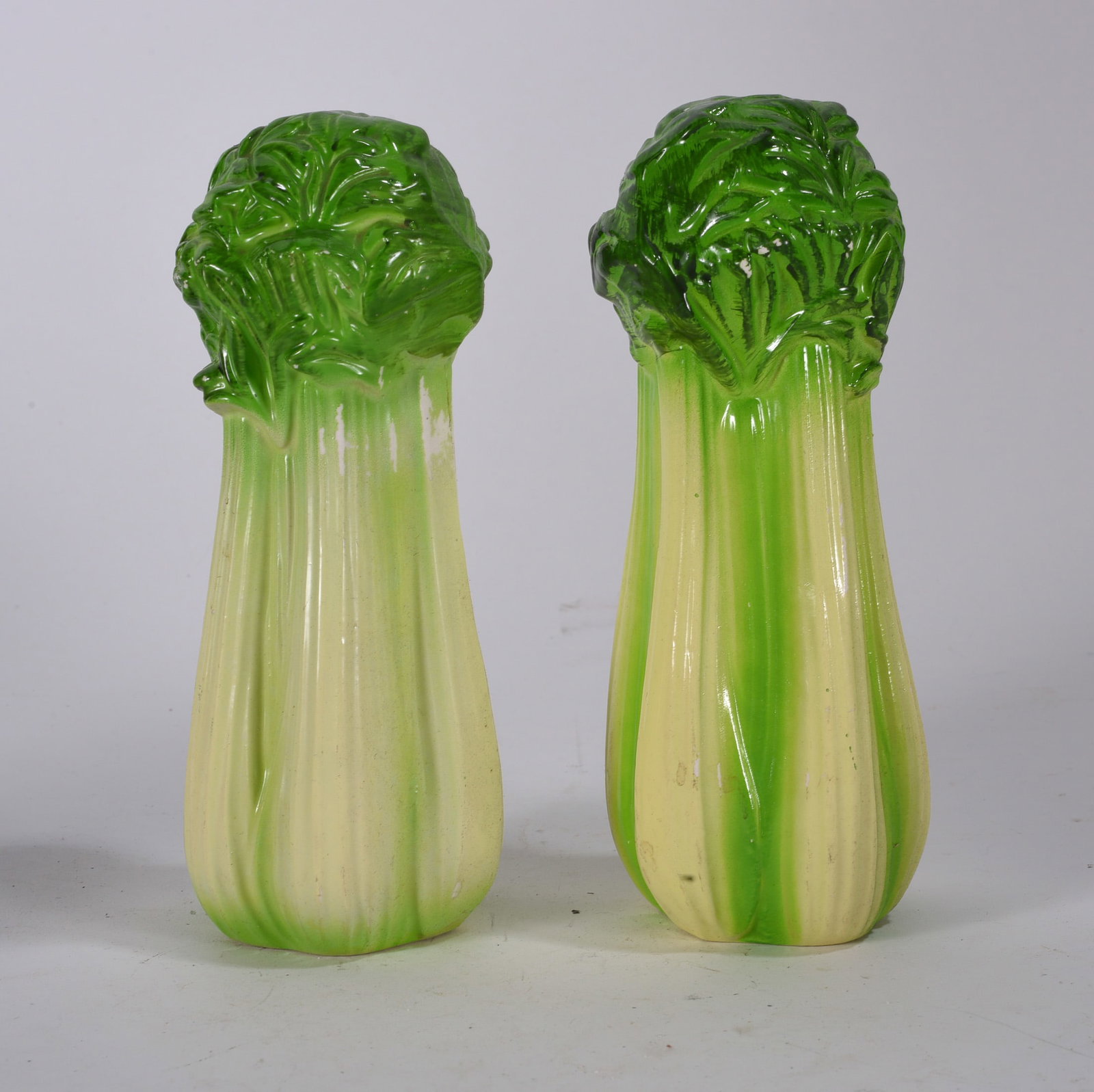 Celery Form Ceramic Salt and Pepper Shakers: Pair of glazed ceramic salt and pepper shakers modeled as celery stalks with green gradient decoration.