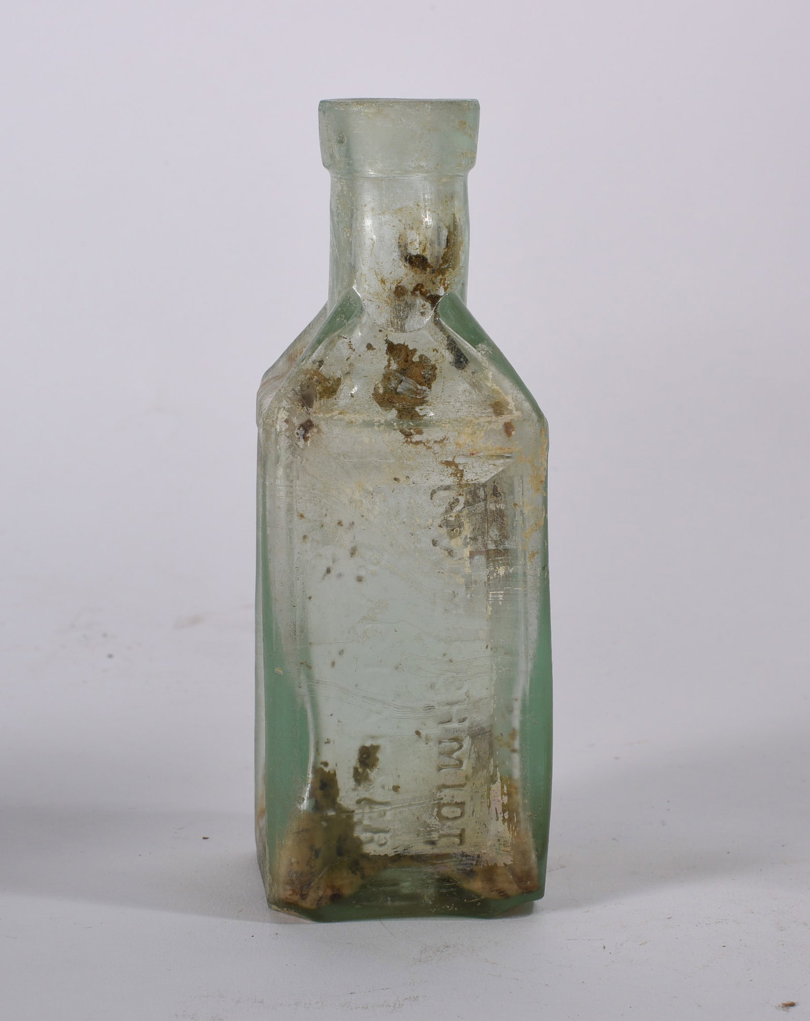 Schmidt Medicine Bottle: Large embossed aqua bottle reading ?HUDICUTS? to body. Cylindrical medicinal form with crude lip and weathered surface.