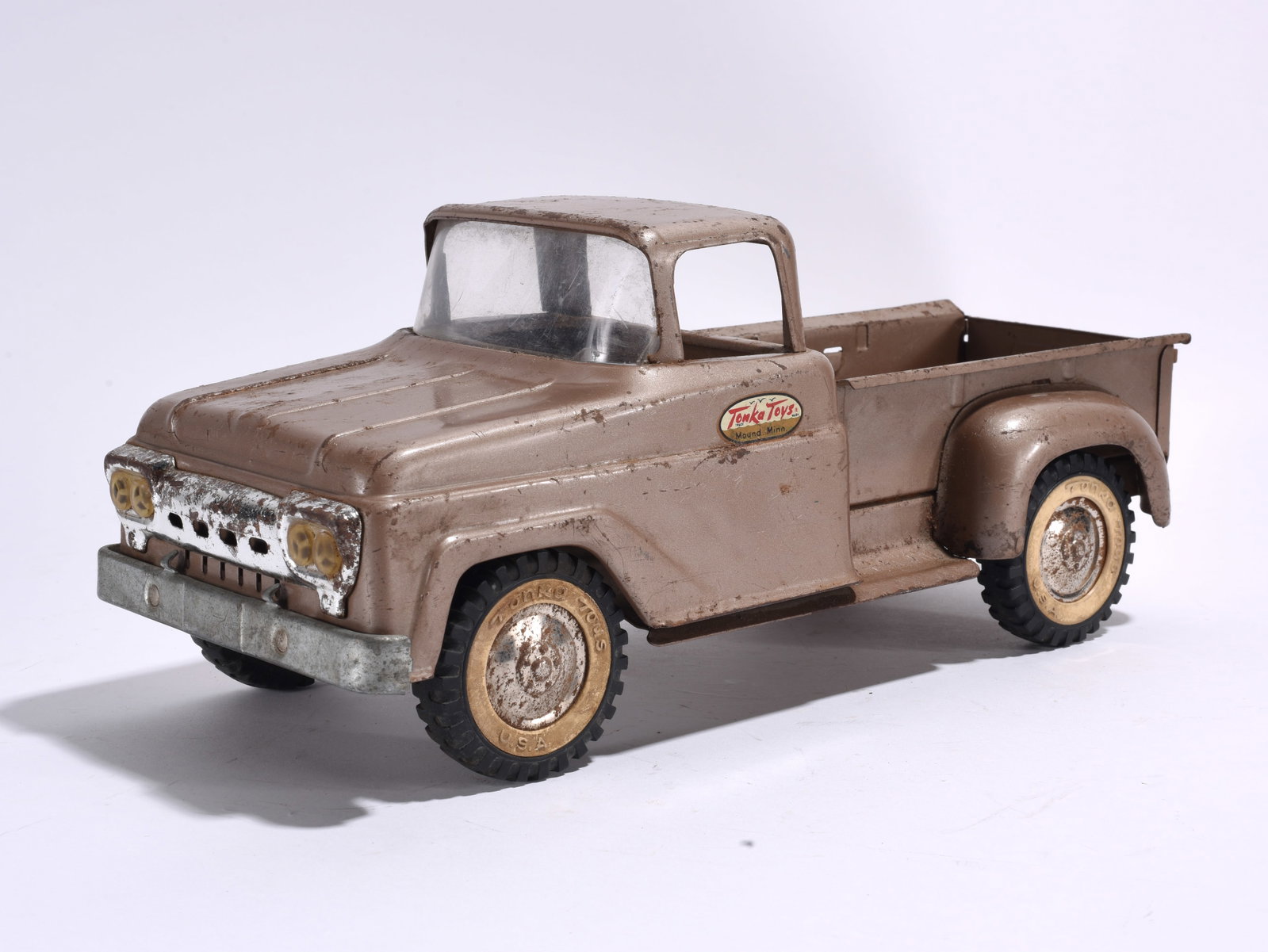 Tonka Pressed Steel Pickup Truck: Tonka pressed steel pickup truck in bronze finish with whitewall-style tires. Moderate oxidation, paint wear, and surface scratches present.