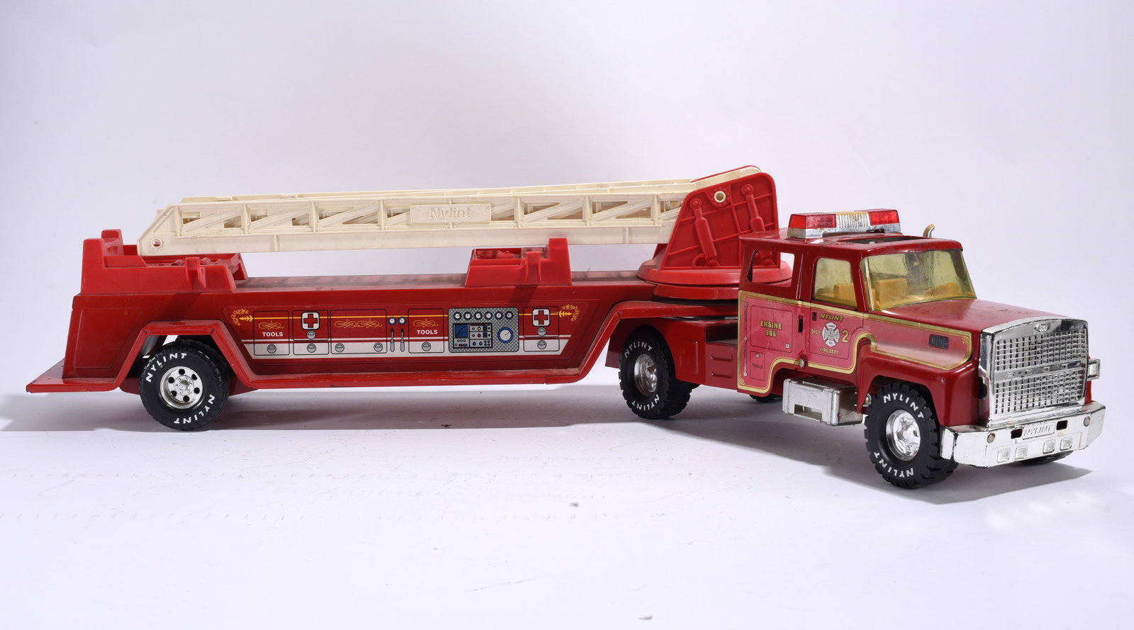 Nylint Fire Department Ladder Truck: Nylint Fire Department ladder truck with rotating aerial ladder and detailed side graphics. General wear and scratching present throughout.