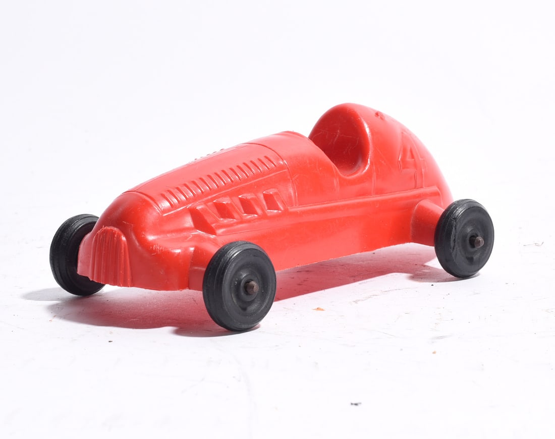 Plastic Open-Wheel Race Car No. 4: Vintage plastic open-wheel race car marked with the number "4." Streamlined red body with black wheels and molded racing details. Light wear from handling and use.