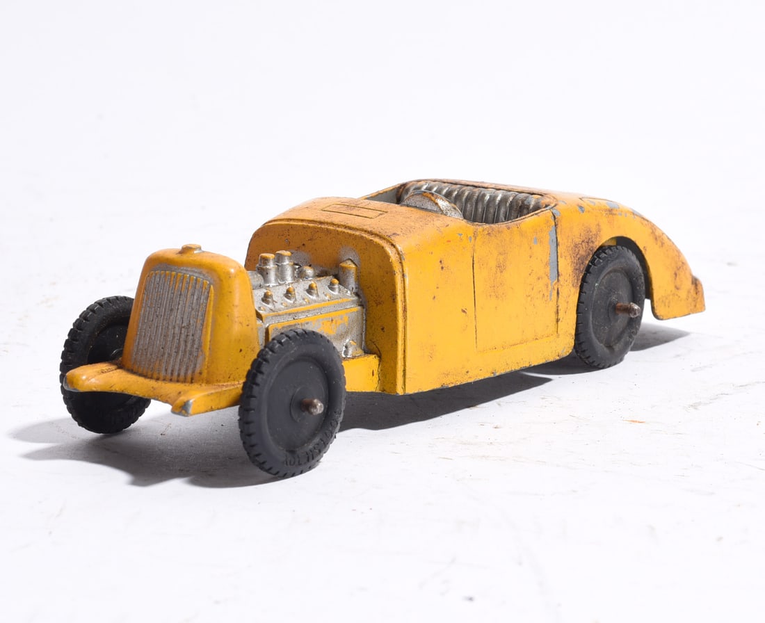 Cast Metal Roadster Race Car: Cast metal roadster race car finished in yellow paint with exposed silver-toned engine detail and open cockpit. Retains black wheels and molded racing features. Wear consistent with age and play use.