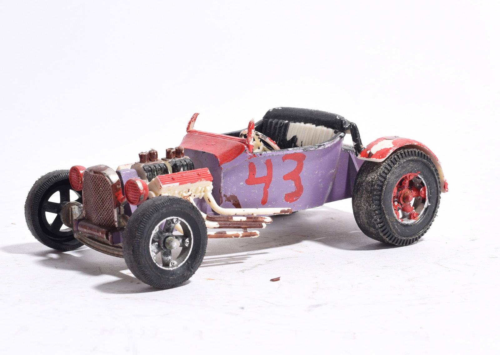 Custom Hot Rod Roadster No. 43 Toy Car: Custom hot rod roadster toy marked with racing number "43." Features exposed engine detail, open cockpit, and custom-painted body in purple and red. Wear, paint loss, and play use evident throughout.