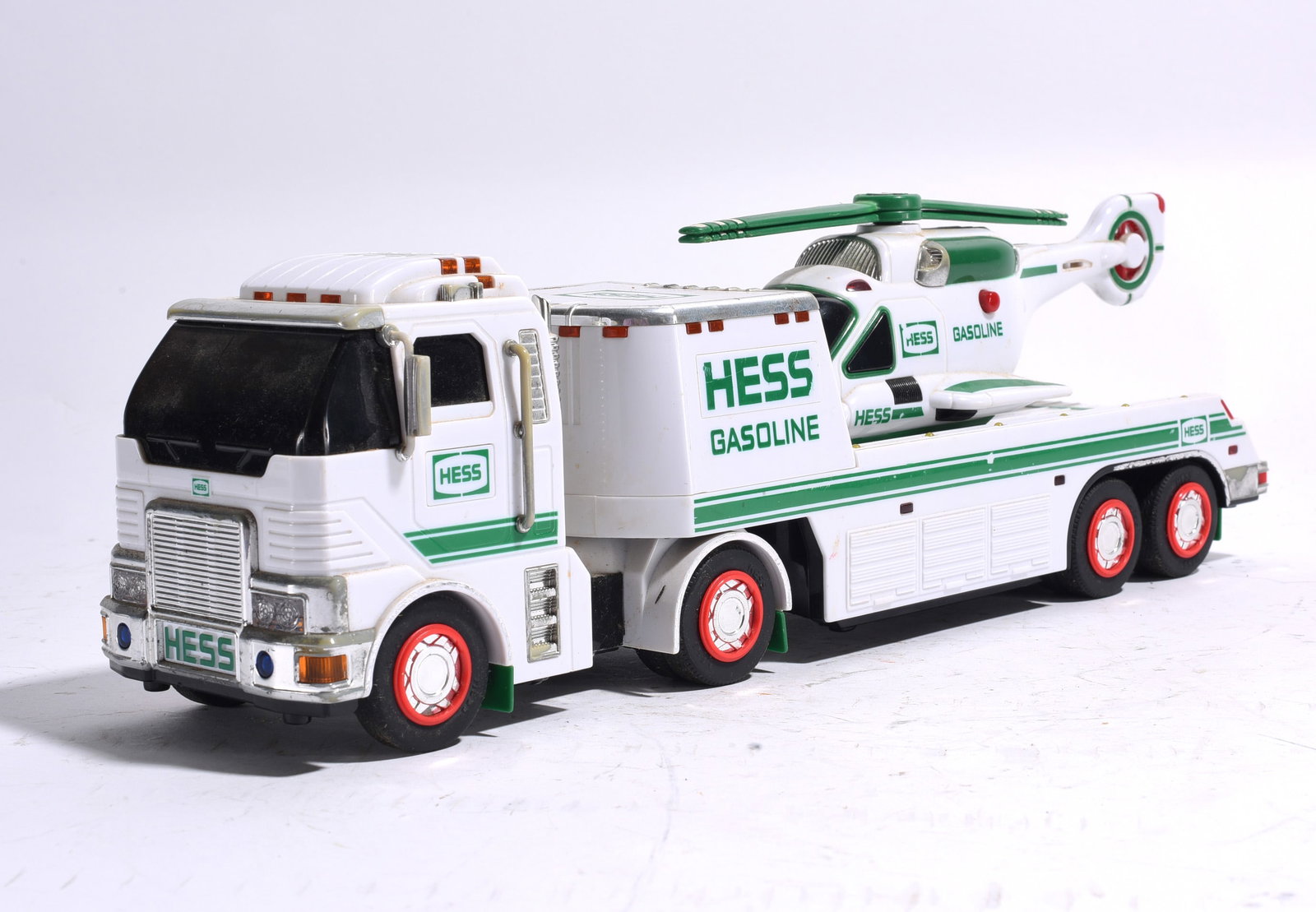 Hess Helicopter Transport Truck: Hess Helicopter Transport Truck consisting of a heavy-duty tractor trailer carrying a Hess helicopter. Retains original decals and molded details. Light wear consistent with age.