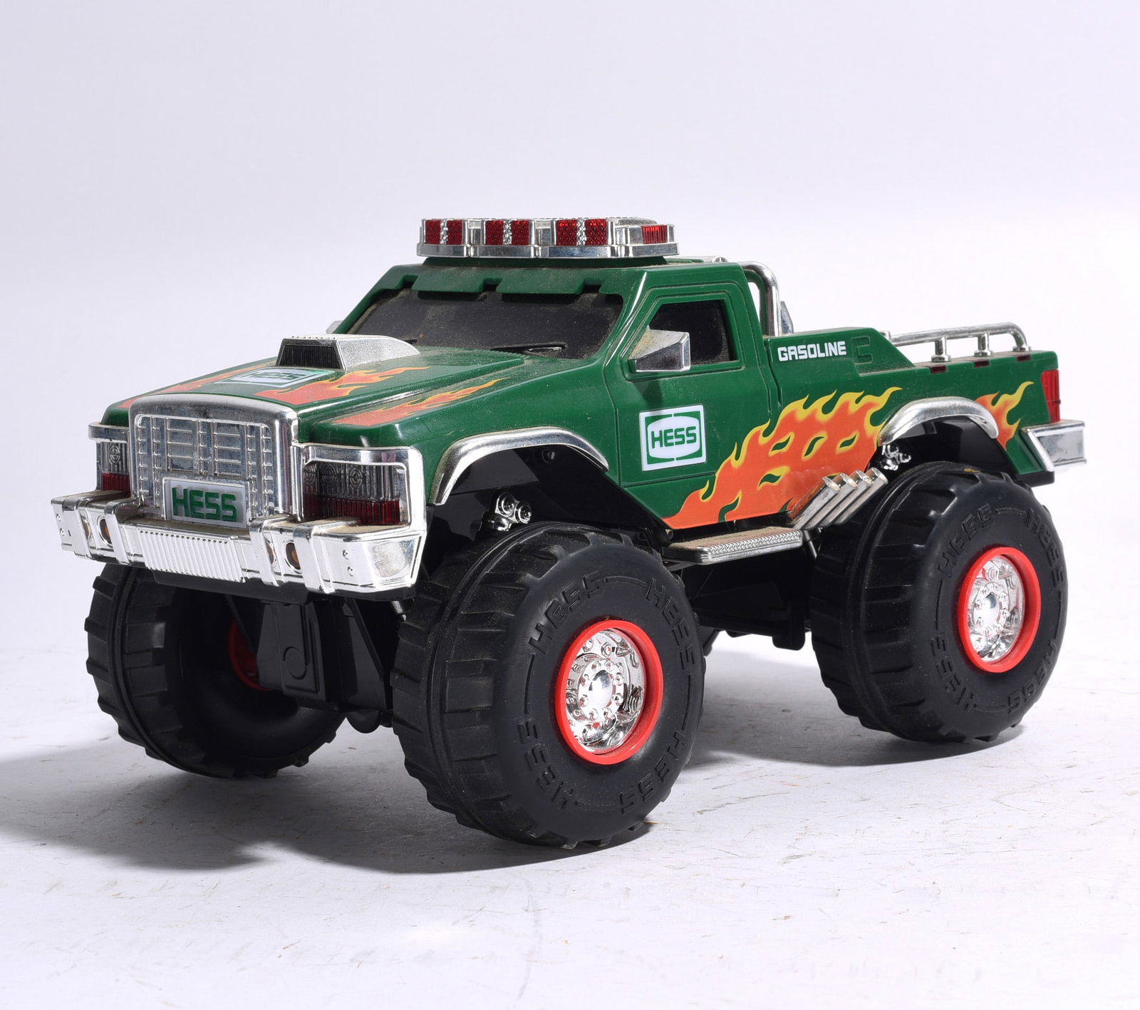 Hess Flatbed Tractor Trailer: Hess Flatbed Tractor Trailer in green and white Hess colors. Features long flatbed trailer, detailed cab, and rolling wheels. Light wear consistent with use.