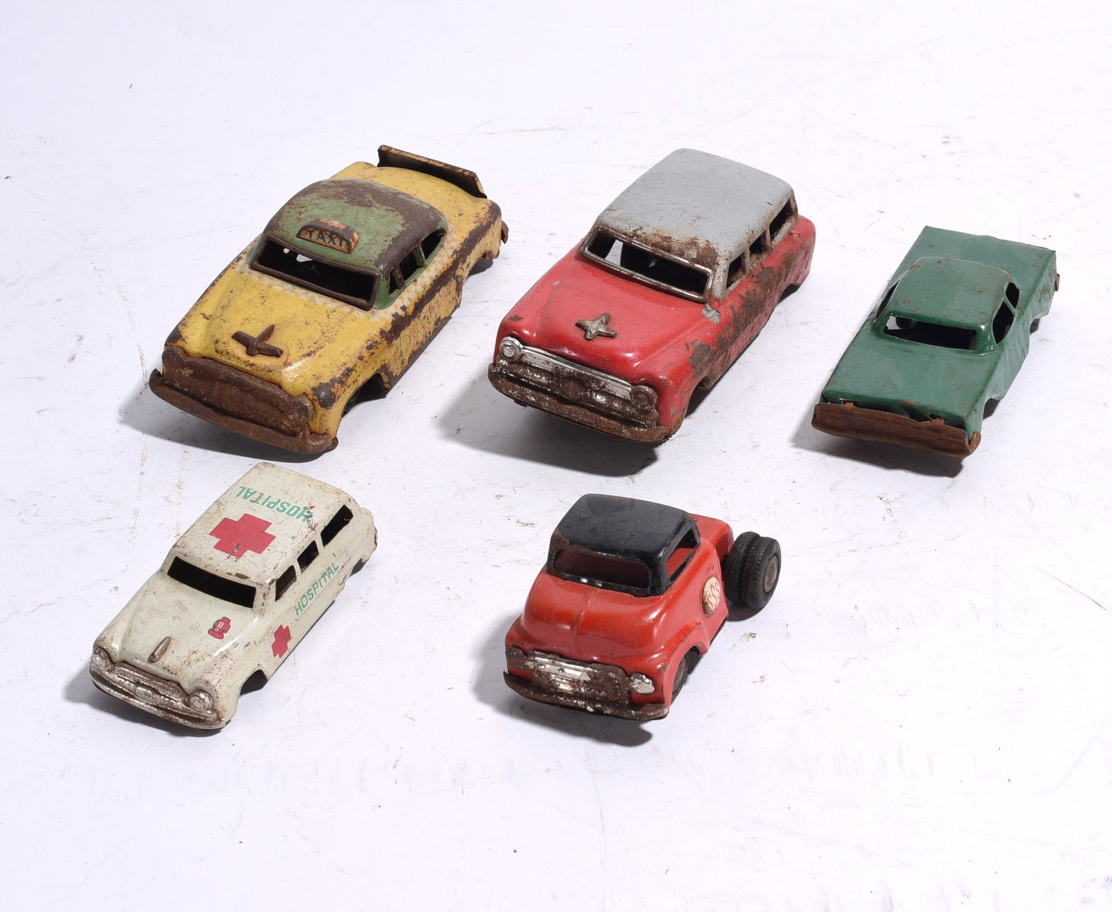 Group of Five Vintage Die-Cast Toy Vehicles: Collection of five vintage die-cast toy vehicles including taxi, ambulance, sedan, and utility vehicle examples. Exhibits paint loss, corrosion, and play wear consistent with age.