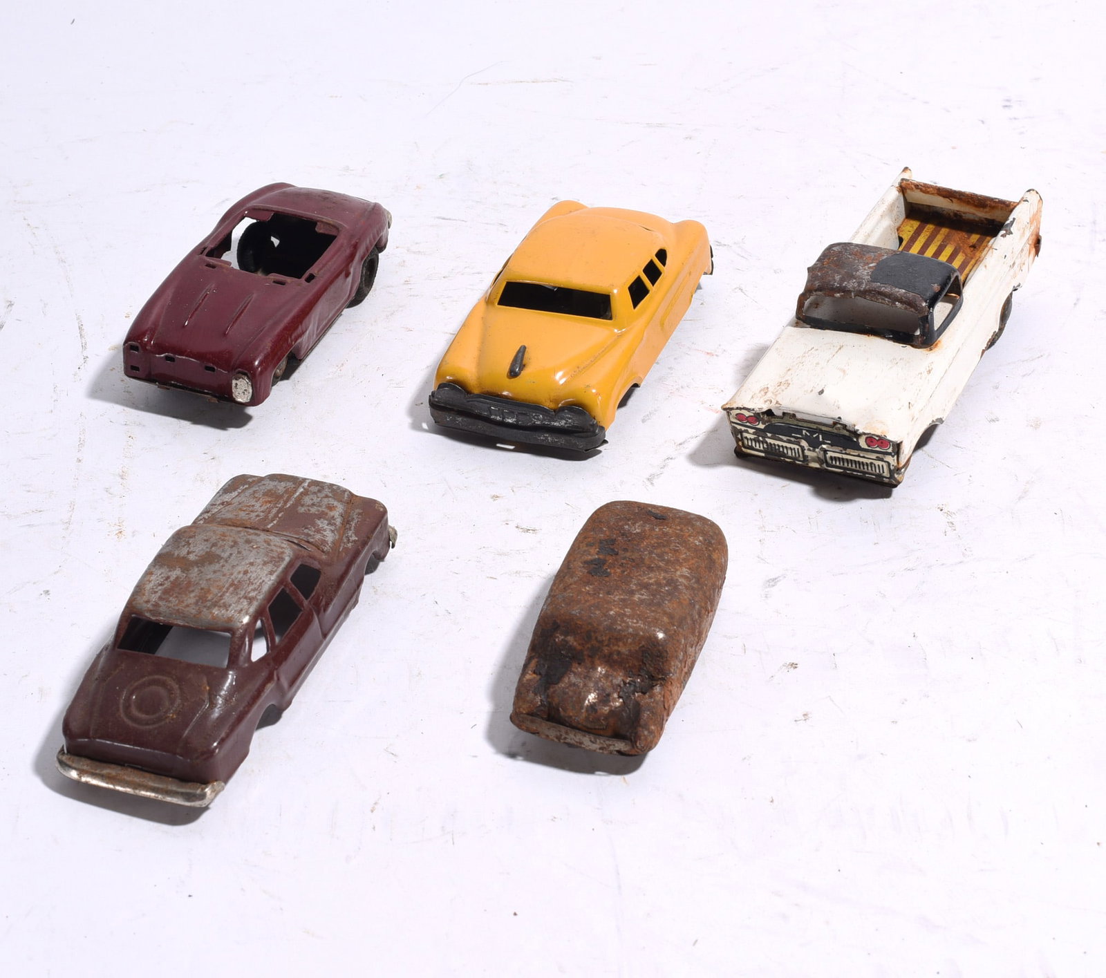 Group of Five Assorted Plastic Toy Vehicles: Group of five plastic toy vehicles including race car, pickup truck, sedan, convertible, and streamlined automobile examples. Bright molded colors with scattered wear and handling marks.